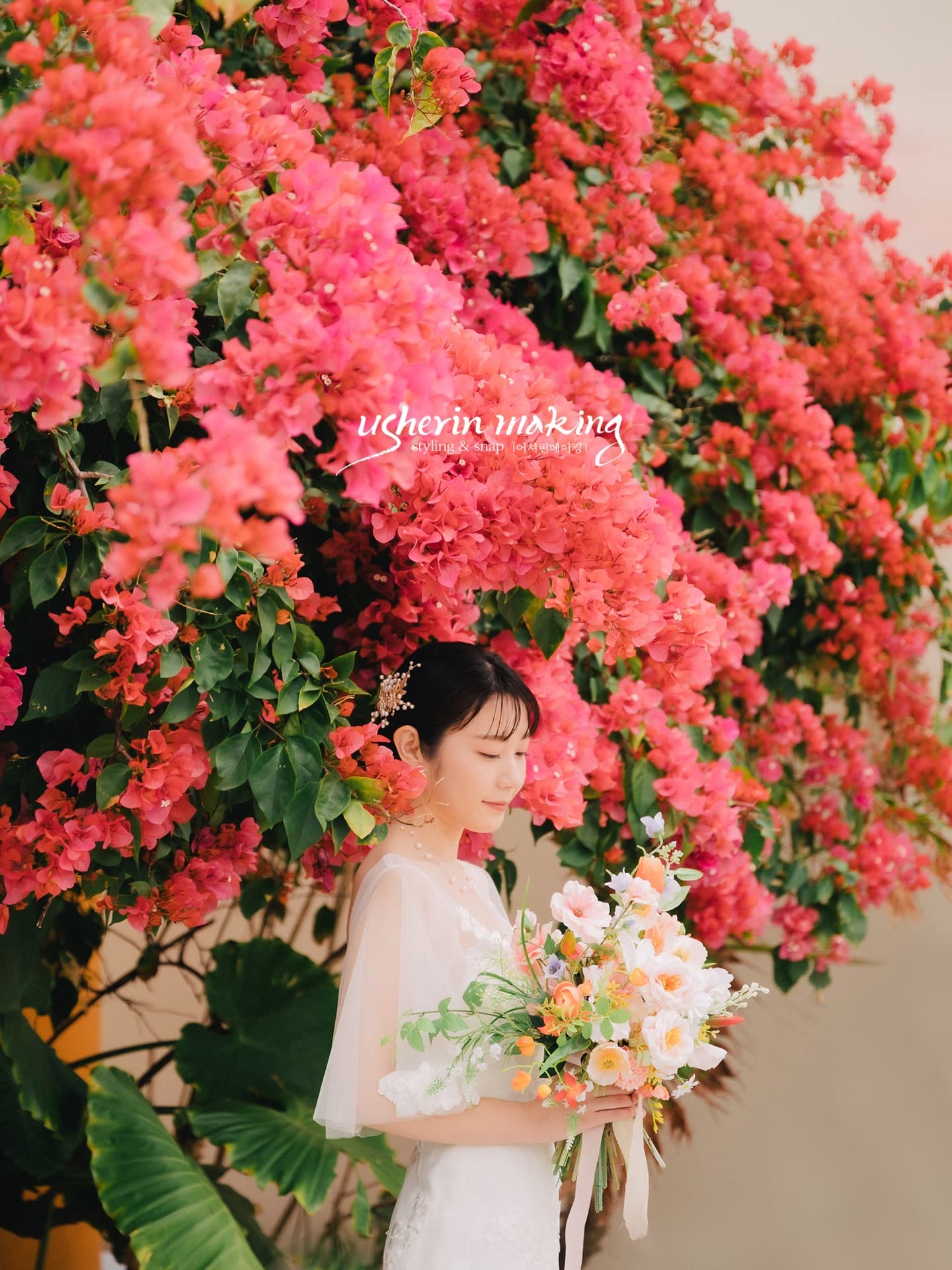 Bride with a pastel bouquet beneath crimson bougainvillea in Okinawa