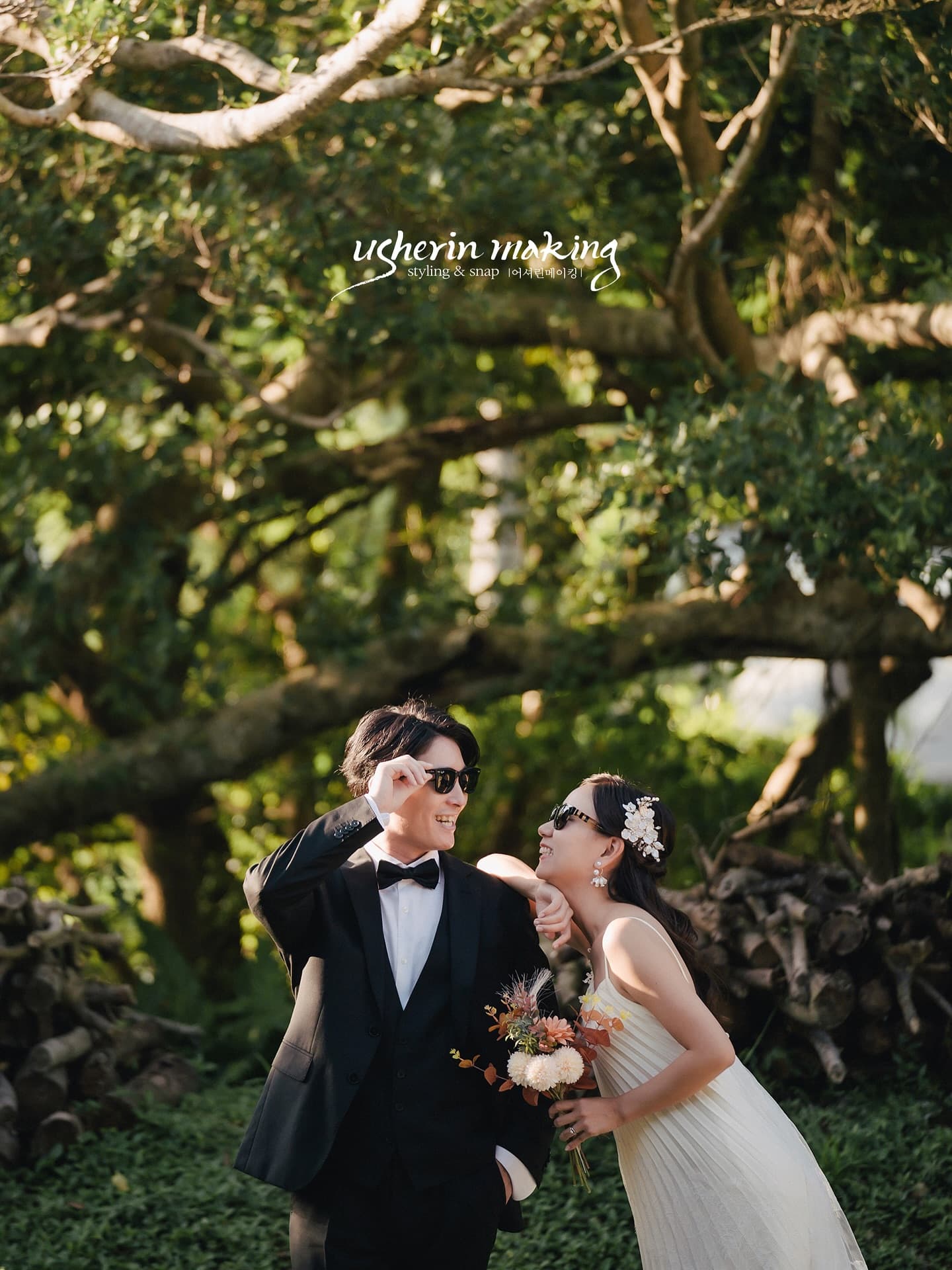 Newlyweds in sunglasses laughing together under a big tree in Okinawa
