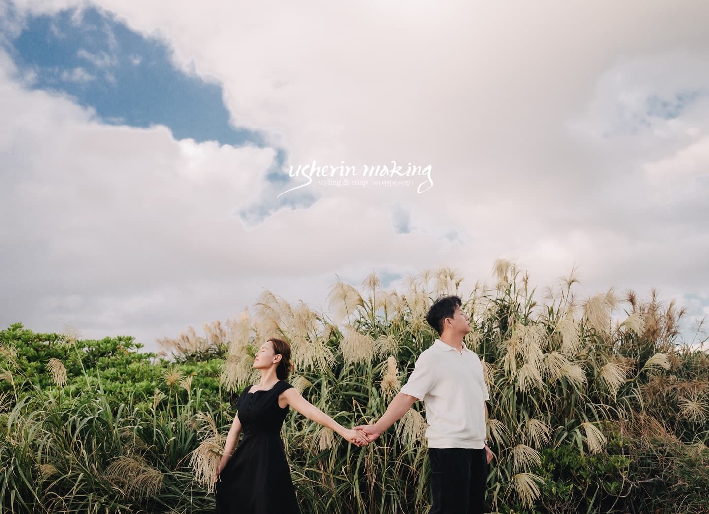 Couple holding hands by silvery pampas grass under a blue Okinawa sky
