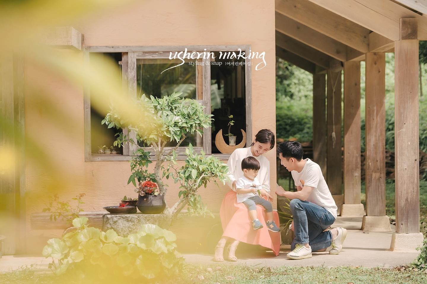 Parents playing with their little boy on the porch of a rustic house in Okinawa