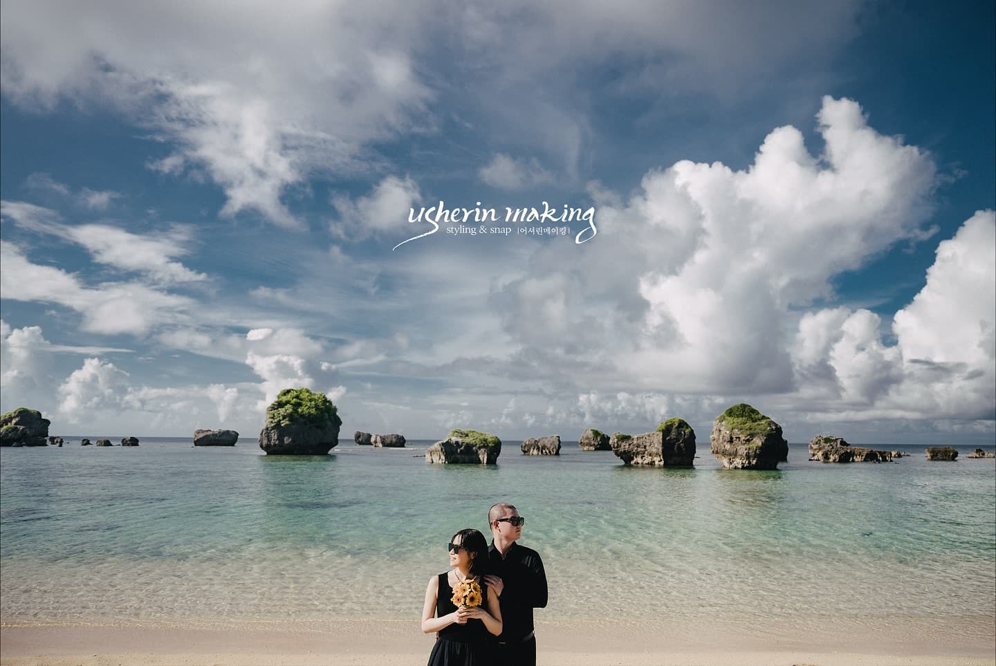 Couple standing close on a Miyakojima beach, rock islets dotting the emerald sea, Okinawa