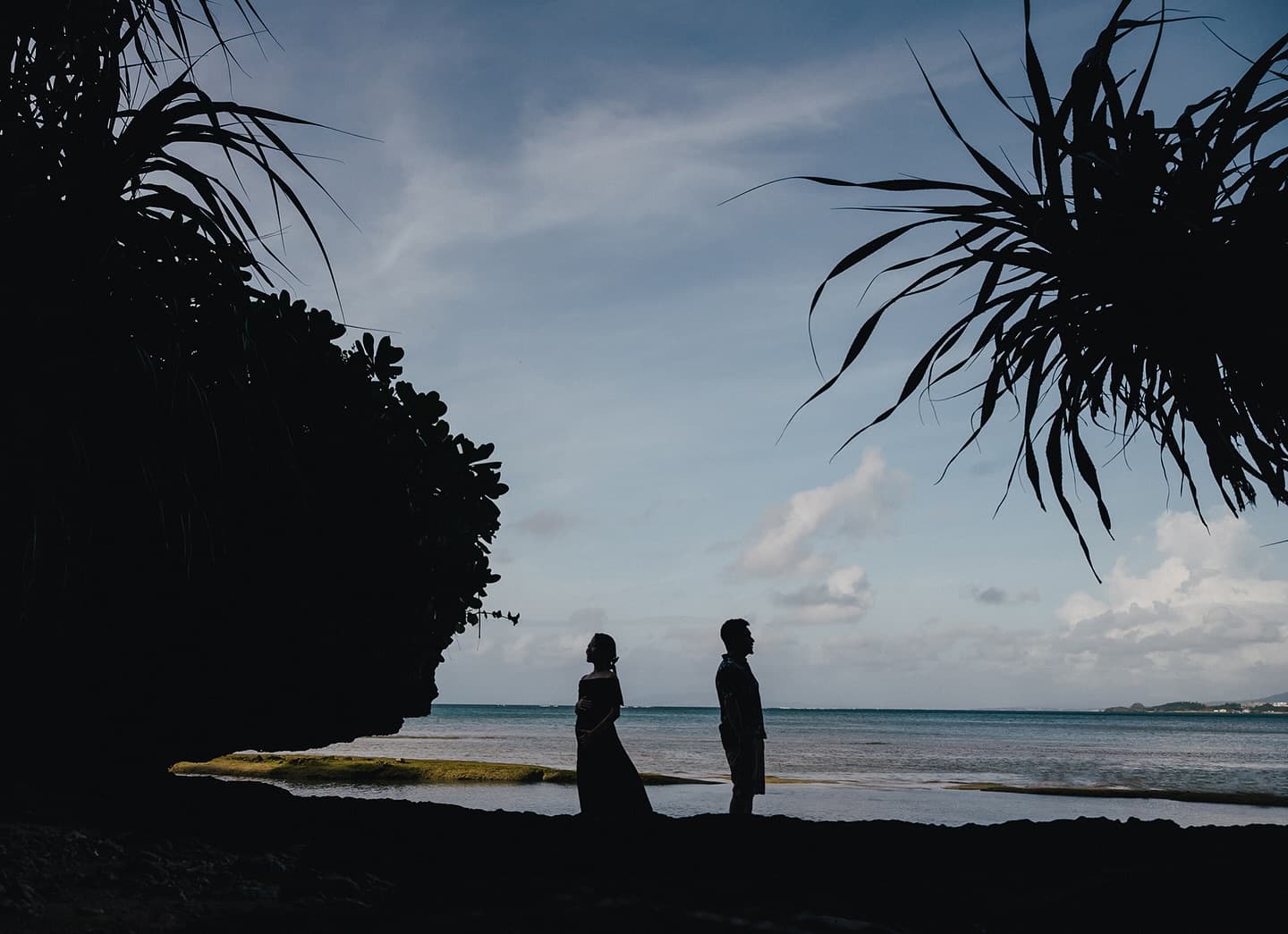 Silhouette of an expecting couple facing each other on an Okinawa beach