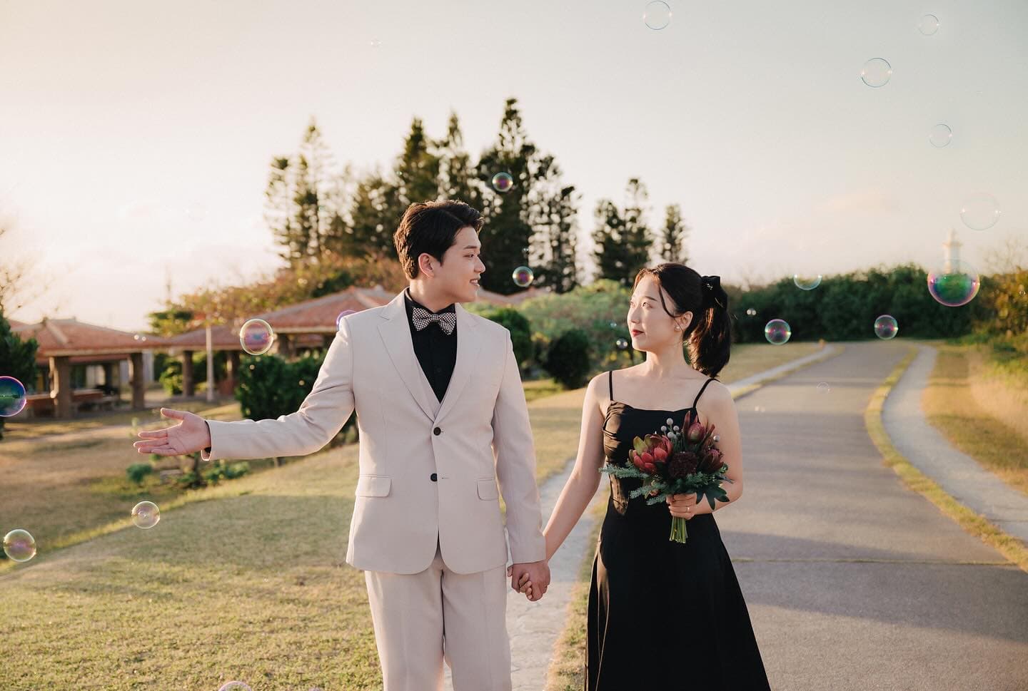 Couple strolling hand in hand through drifting bubbles in Okinawa