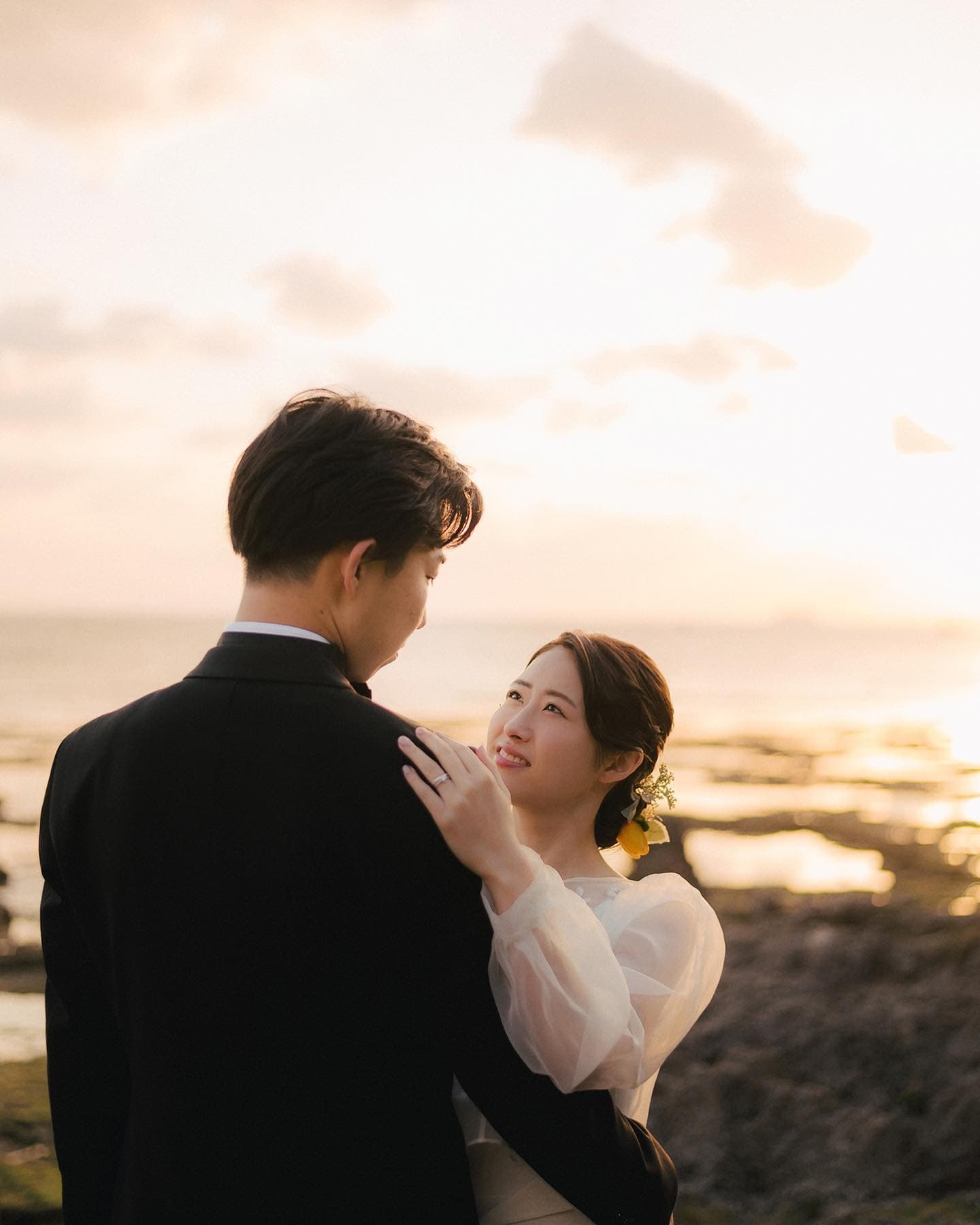노을빛으로 물든 오키나와 바닷가에서 신랑을 바라보는 신부