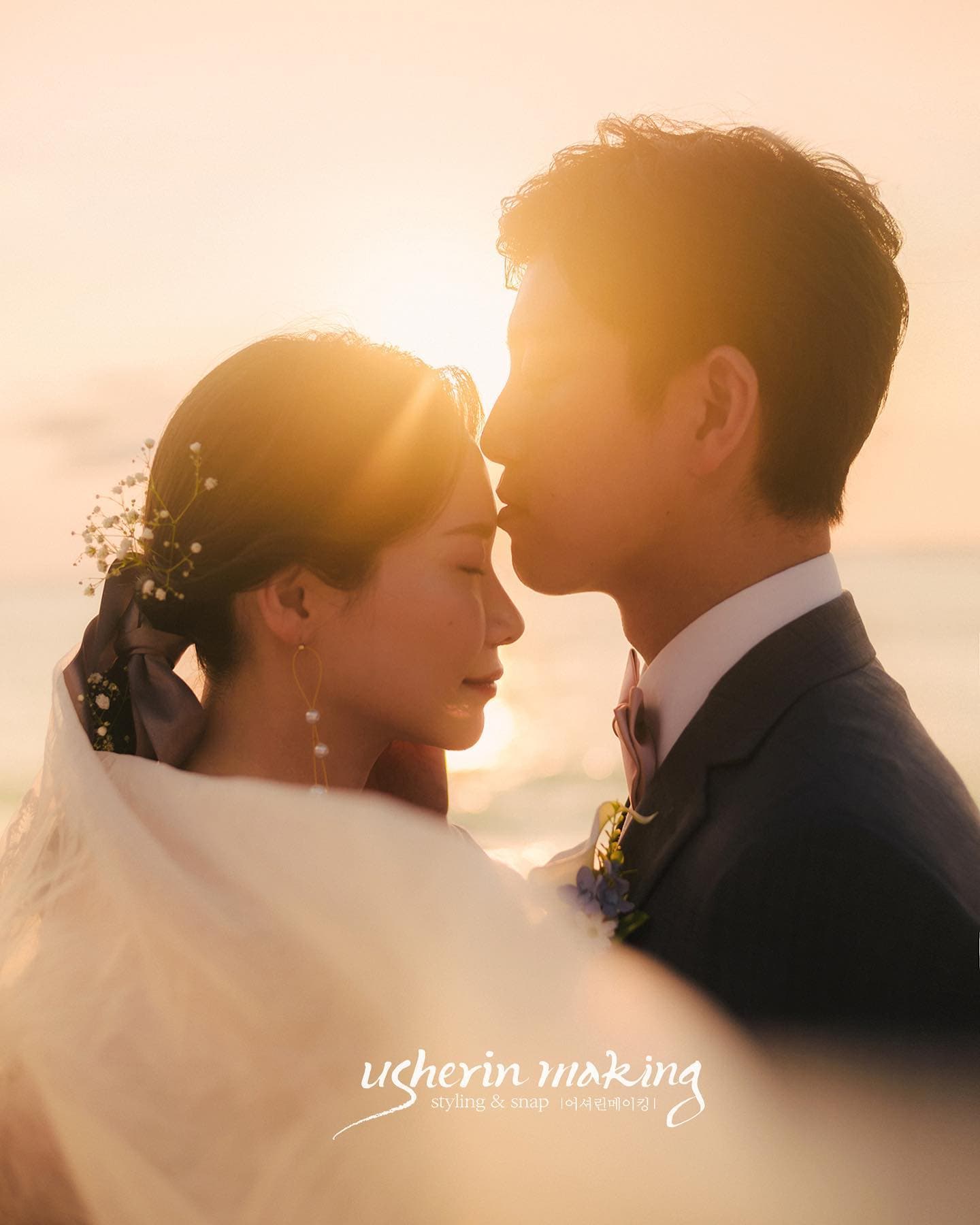 夕焼けの沖縄の海辺で、額にキスを受ける花嫁のクローズアップ