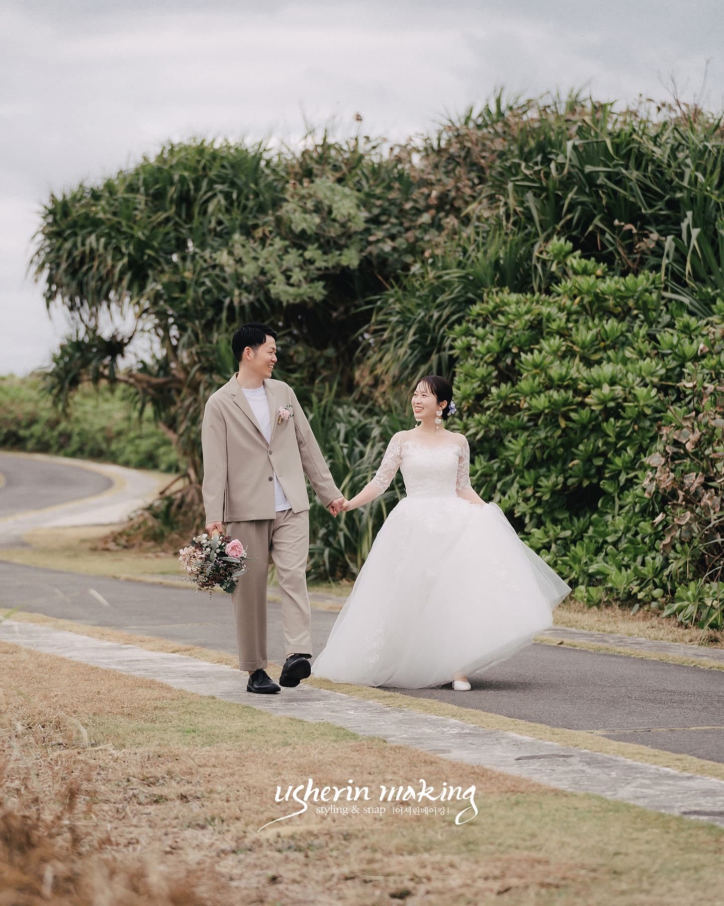 Couple walking along a leafy path in Okinawa under soft overcast light
