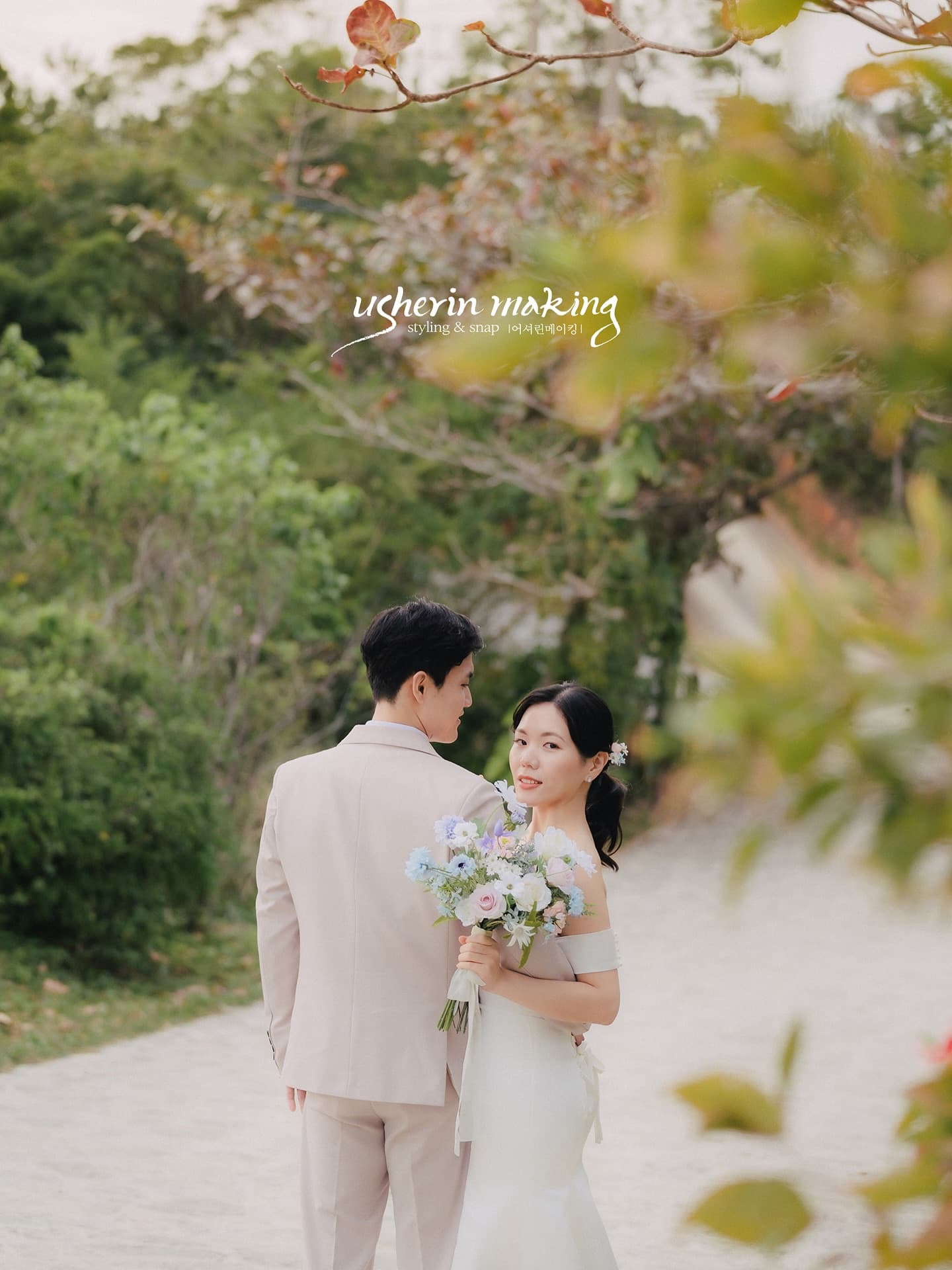 Bride glancing back with her bouquet on a white path in Okinawa