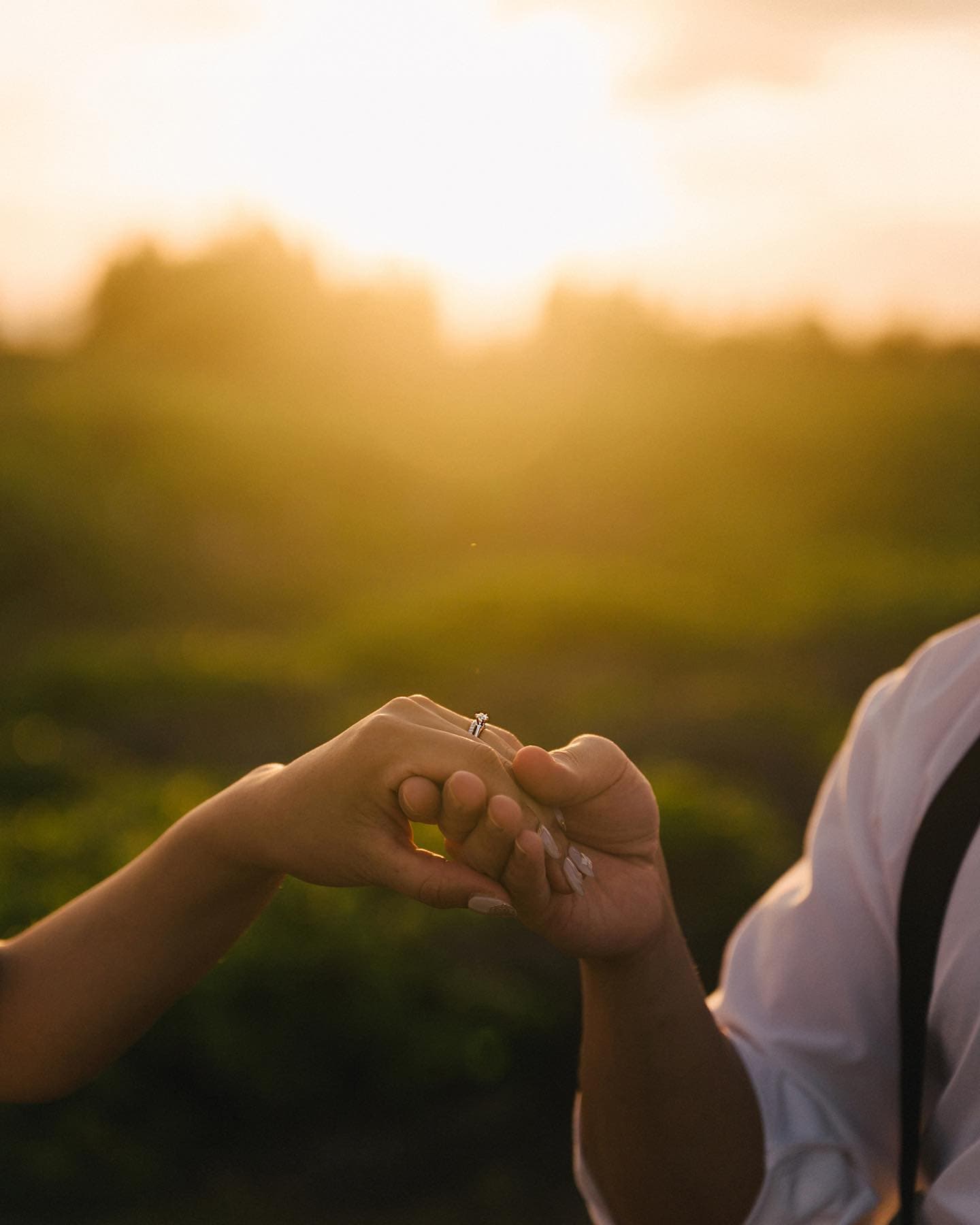 Two hands linked at sunset, a wedding ring catching the Okinawa light