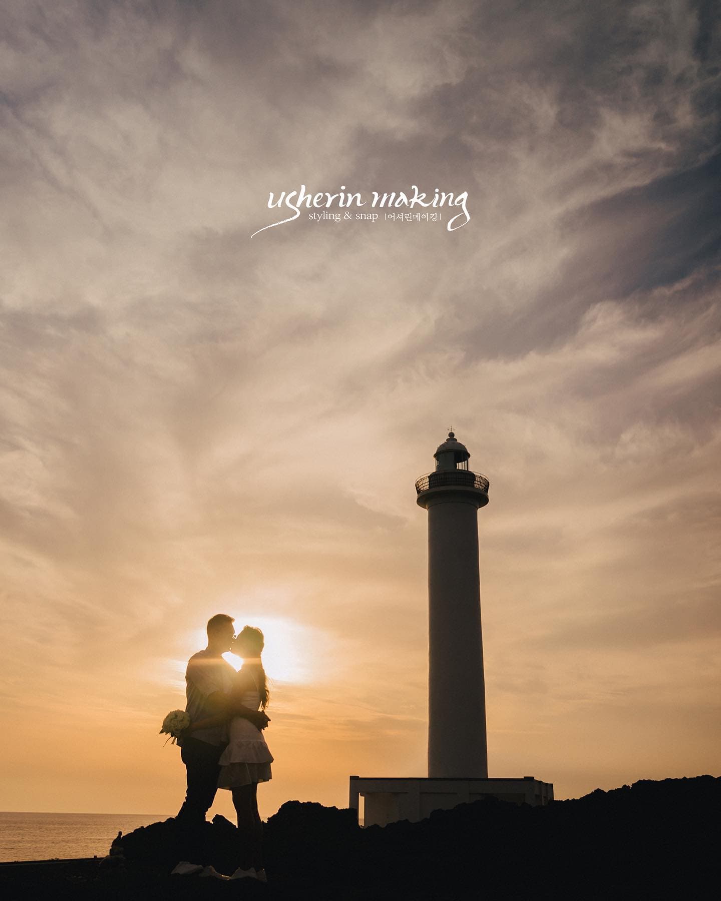 Silhouetted couple kissing beside a lighthouse at sunset on an Okinawa cape