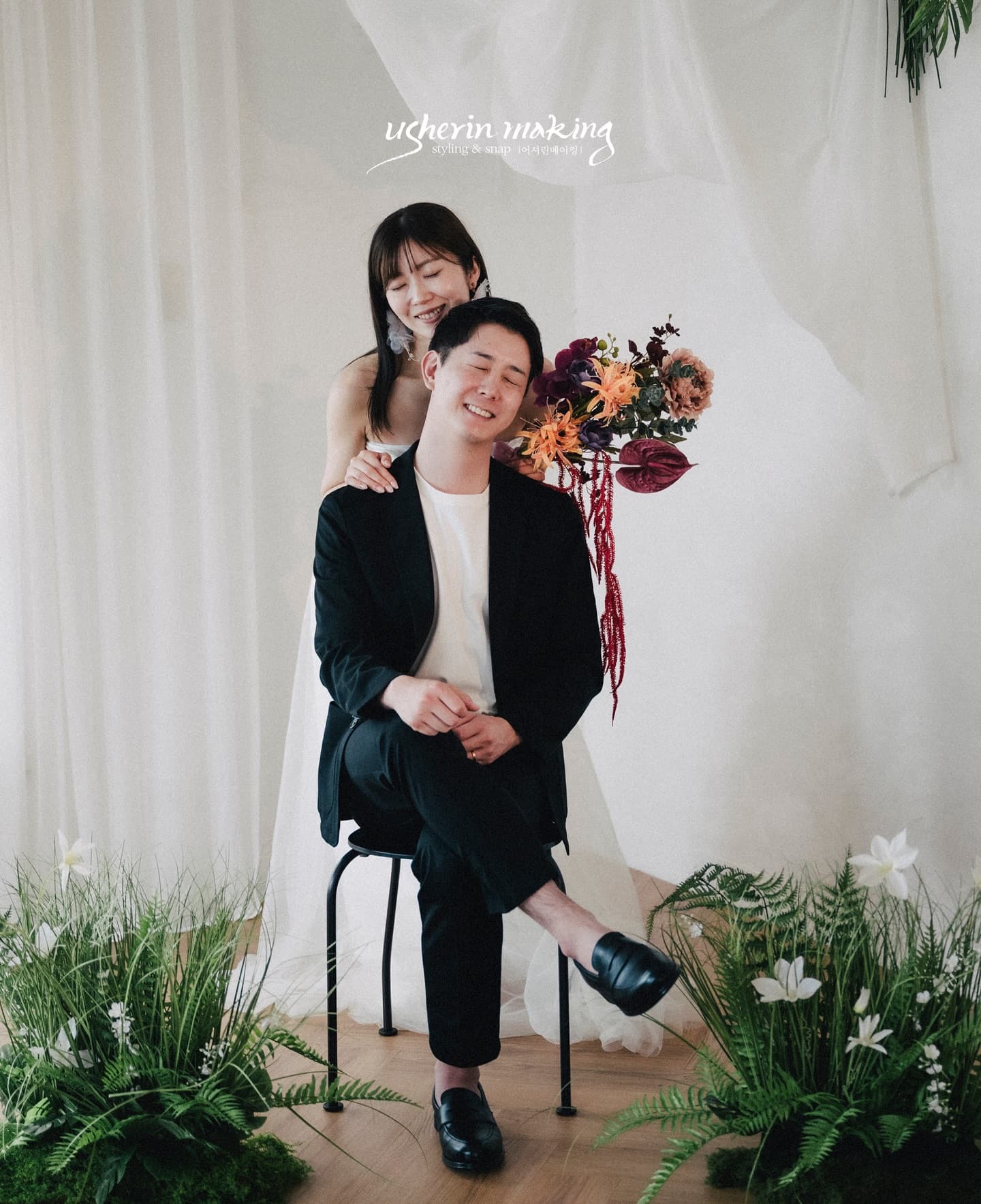 椅子に座る新郎を後ろから抱きしめる新婦、秋色ブーケの韓国風スタジオフォト
