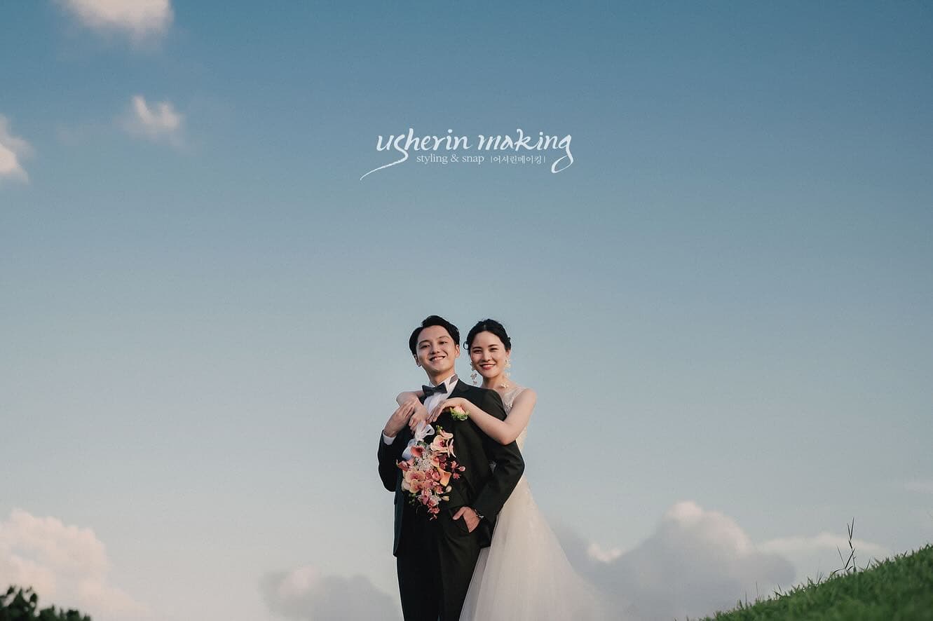 青空の丘の上、ブーケを手にハートを作る新郎新婦、沖縄ウェディング