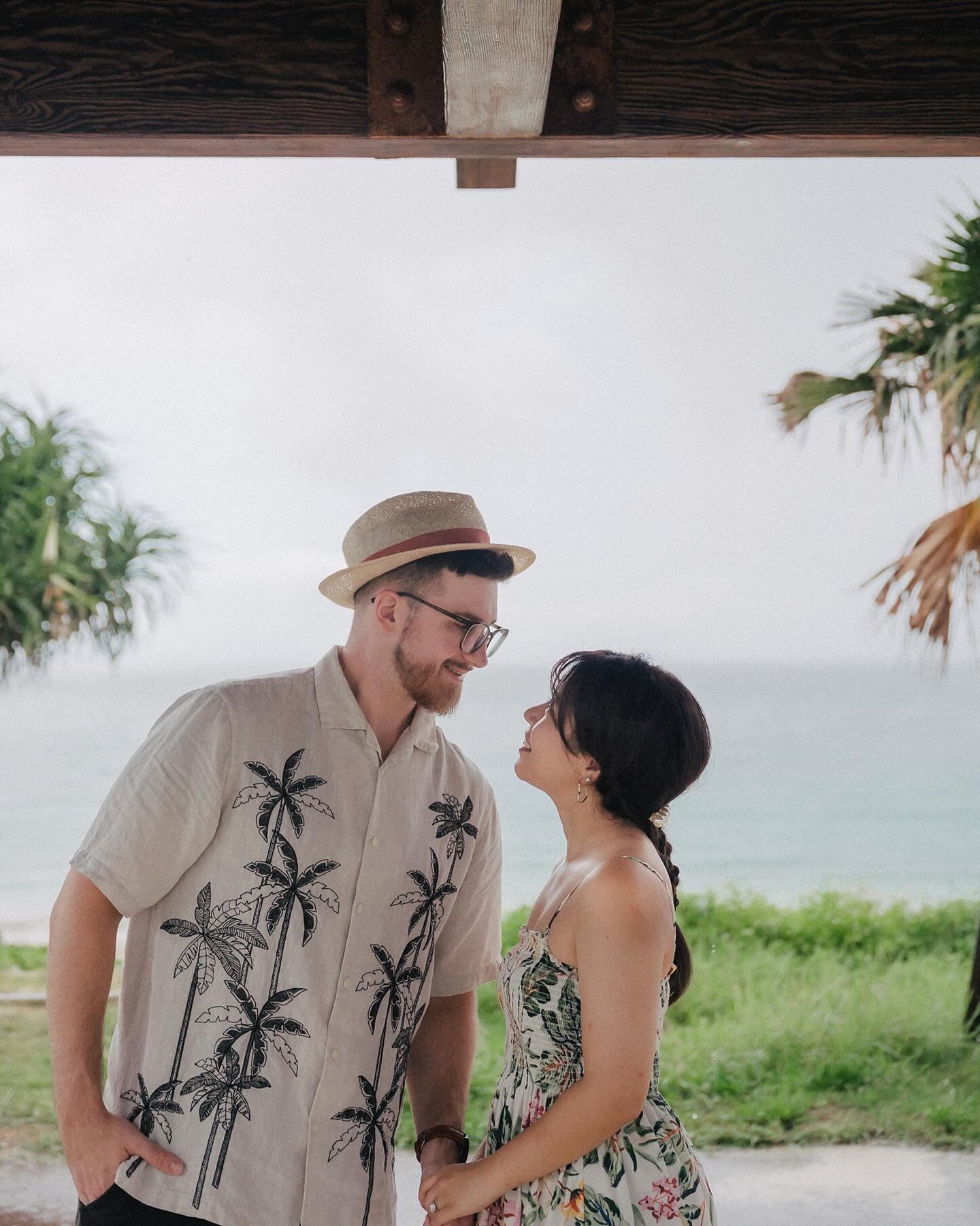 Couple face to face under a seaside pavilion on a cloudy Okinawa day