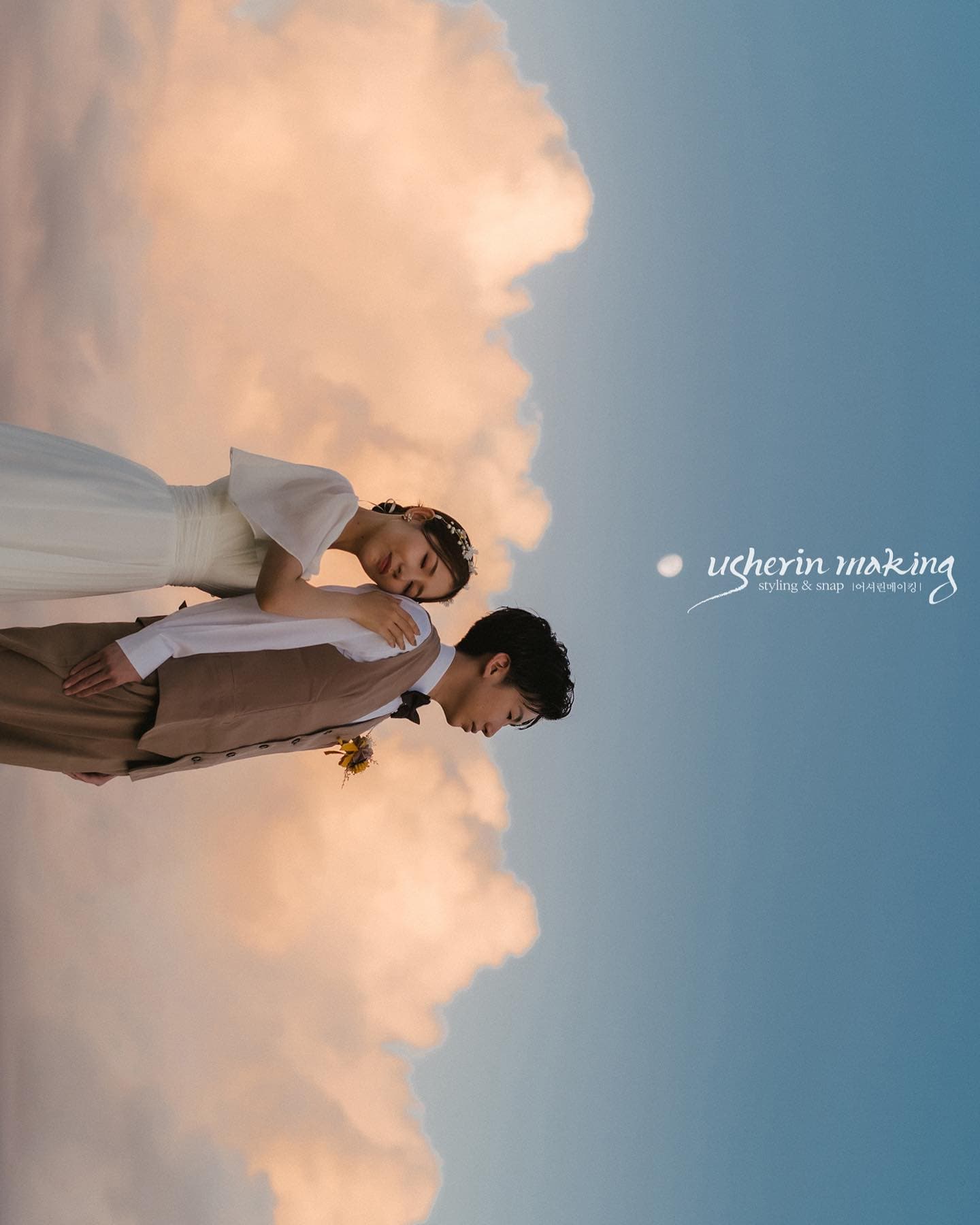 Bride and groom framed against glowing clouds and deep blue sky in Okinawa