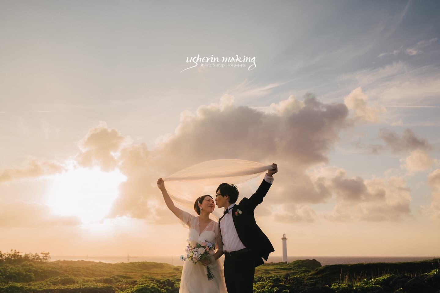 Couple kissing under a raised veil at sunset by an Okinawa lighthouse