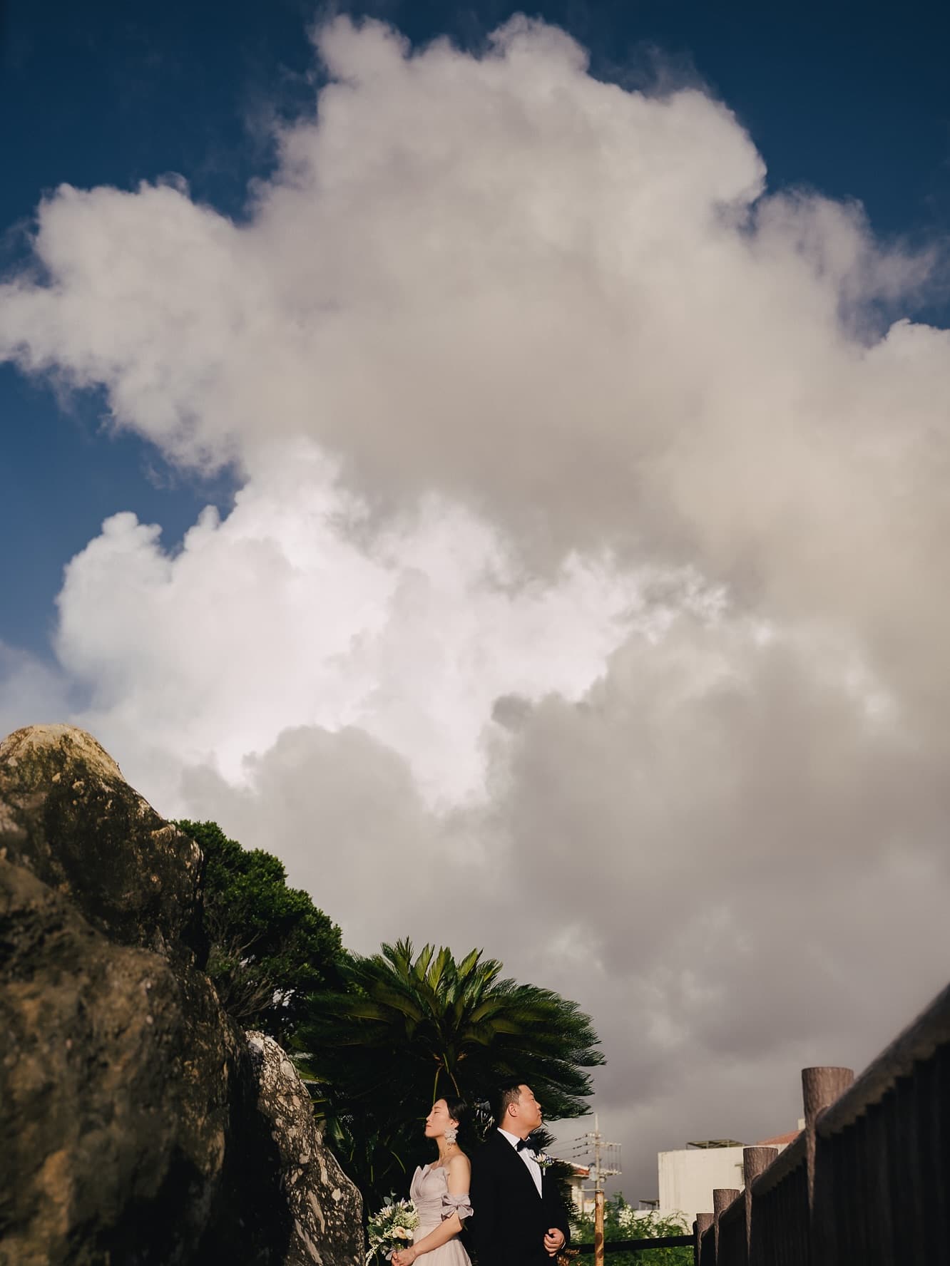 Towering white clouds over Okinawa with the couple small below