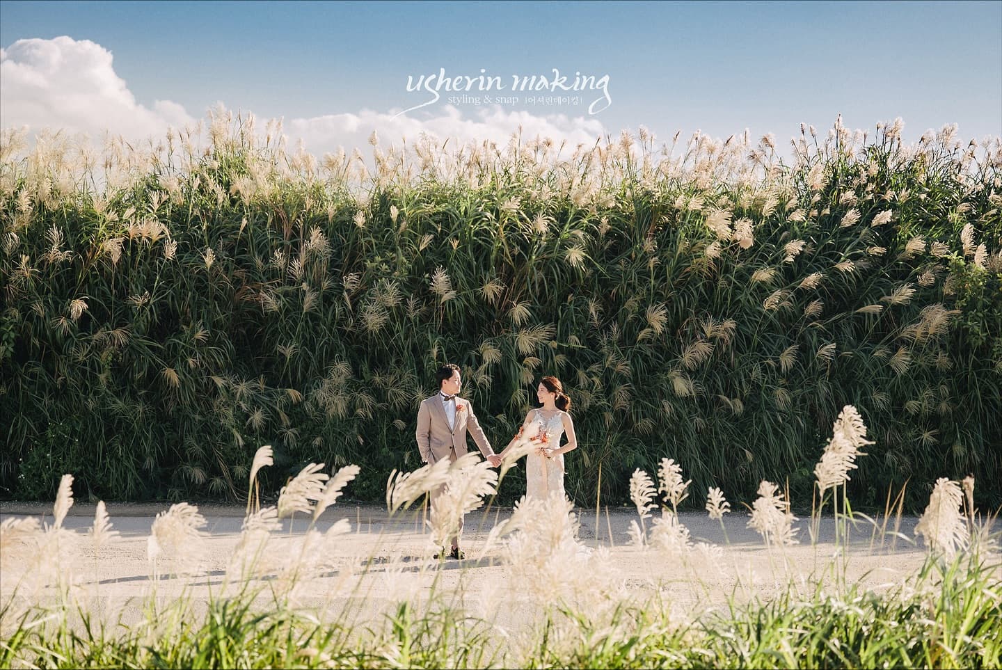 Couple facing each other among pampas plumes under a blue Okinawa sky