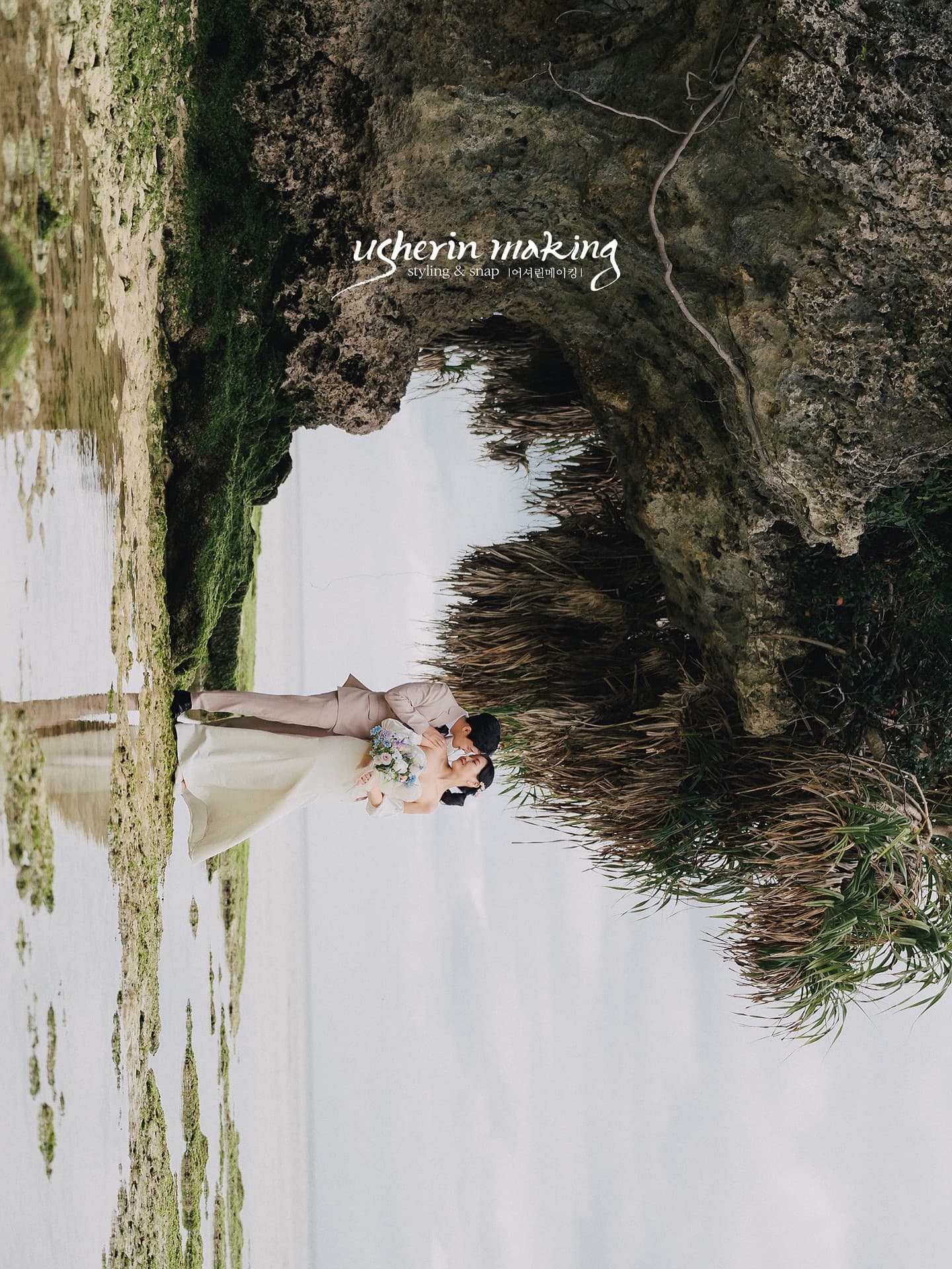 Couple embracing on tidal flats beneath a rocky cliff in Okinawa