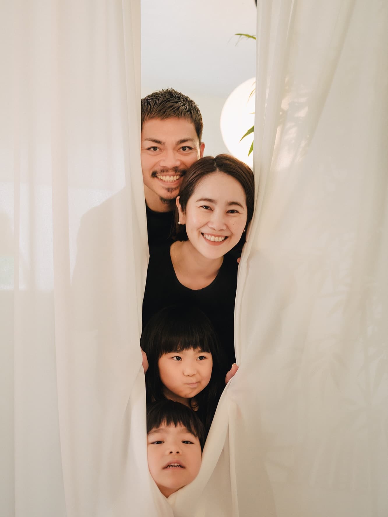 하얀 커튼 사이로 얼굴을 내밀며 웃는 네 가족, 스튜디오 촬영