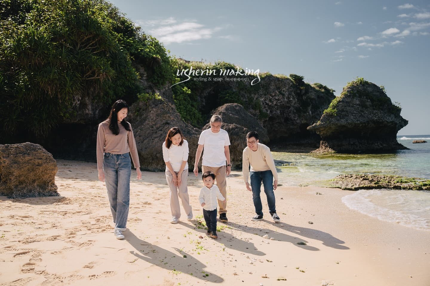 Family of five strolling along a rocky beach on a sunny day in Okinawa