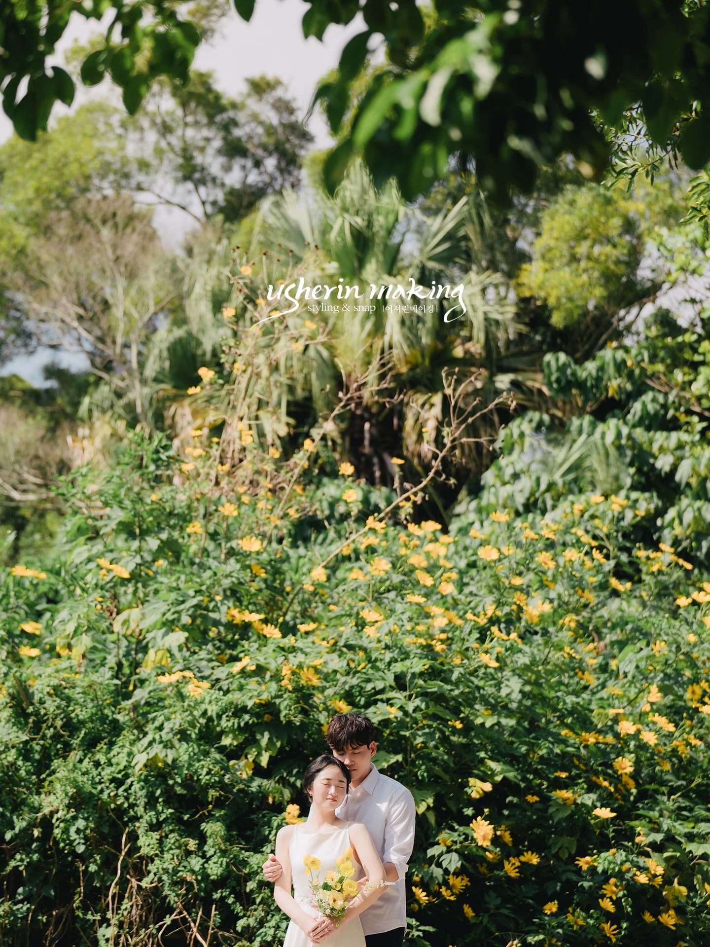 Groom embracing the bride from behind among yellow wildflowers in Okinawa