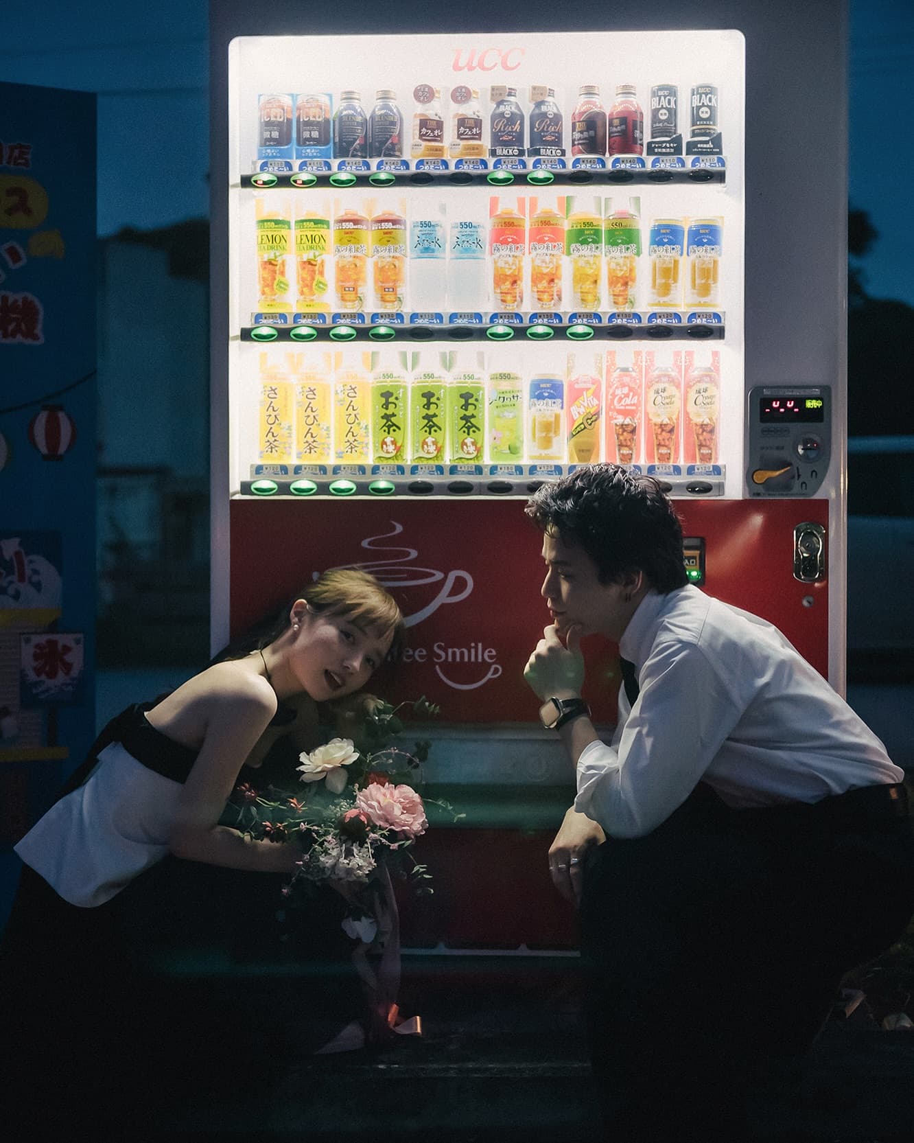 Bride holding a bouquet by a lit vending machine on an Okinawa night