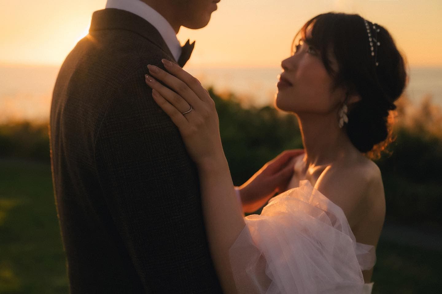 Bride gazing up at her groom in the warm light of an Okinawa sunset