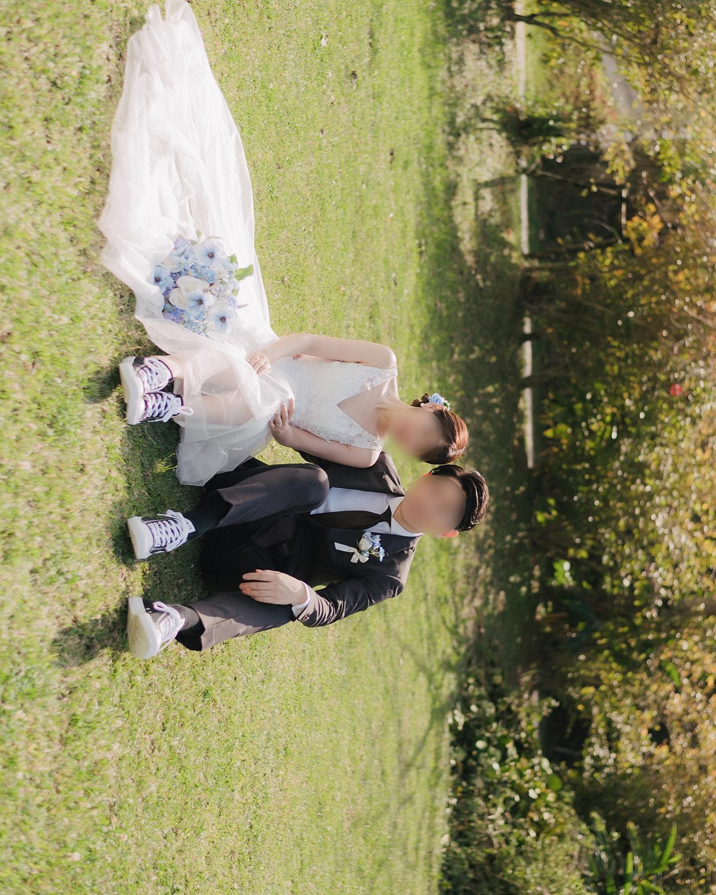 Couple relaxing on the grass with a blue bouquet and matching sneakers