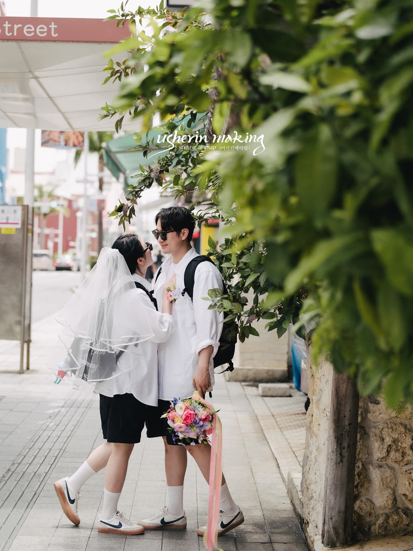 가로수 녹음 사이 인도에서 마주 선 커플, 파스텔 부케의 오키나와 스냅