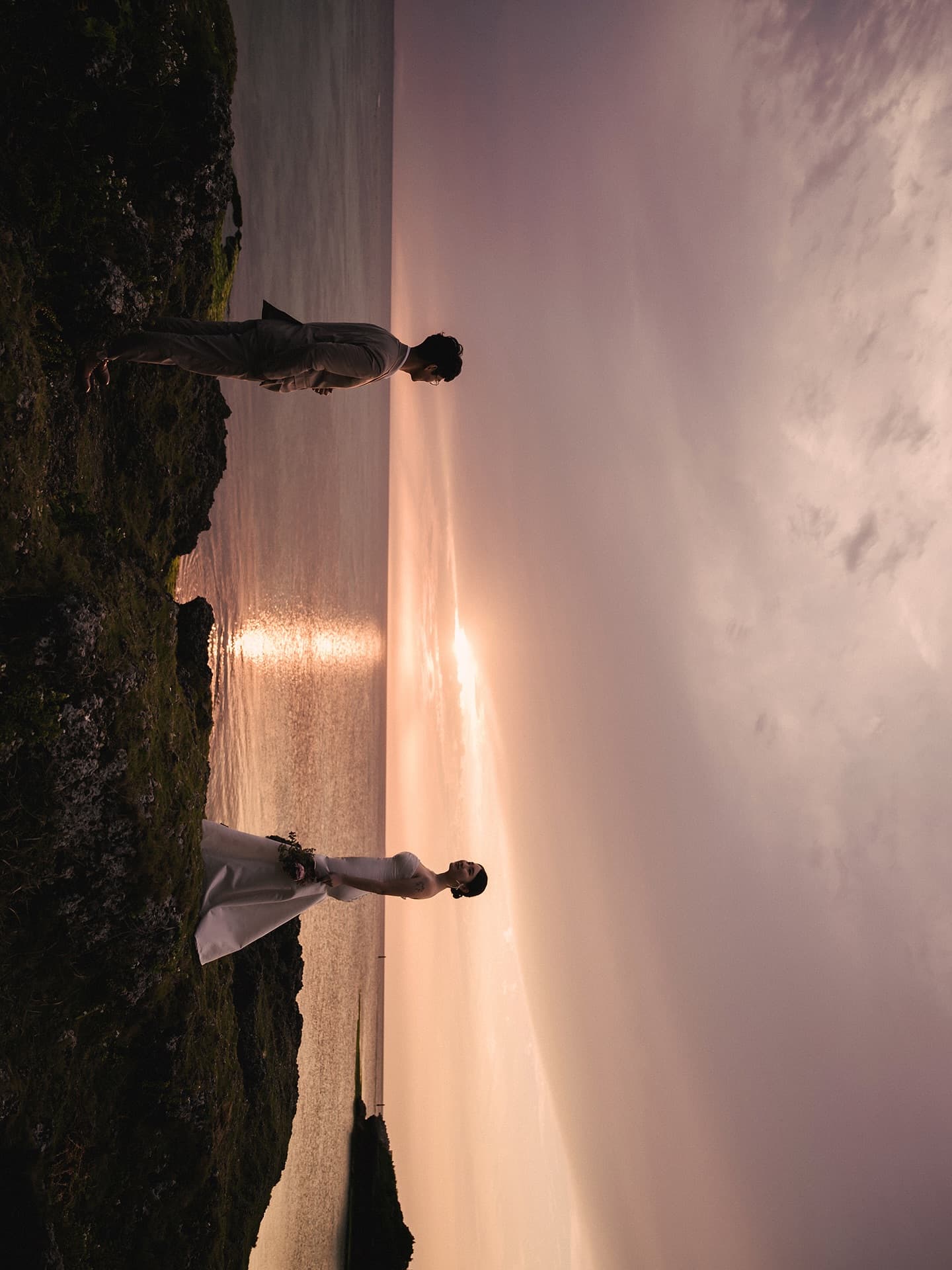 Bride and groom on a seaside cliff at dusk in Okinawa