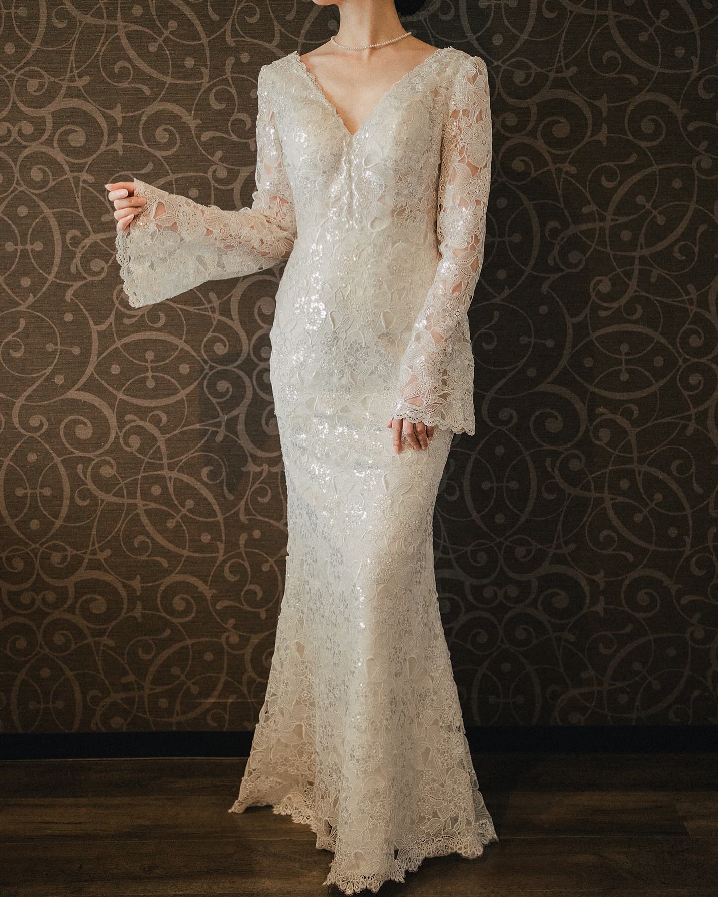 Silver-toned lace mermaid gown with long bell sleeves, full length from the front