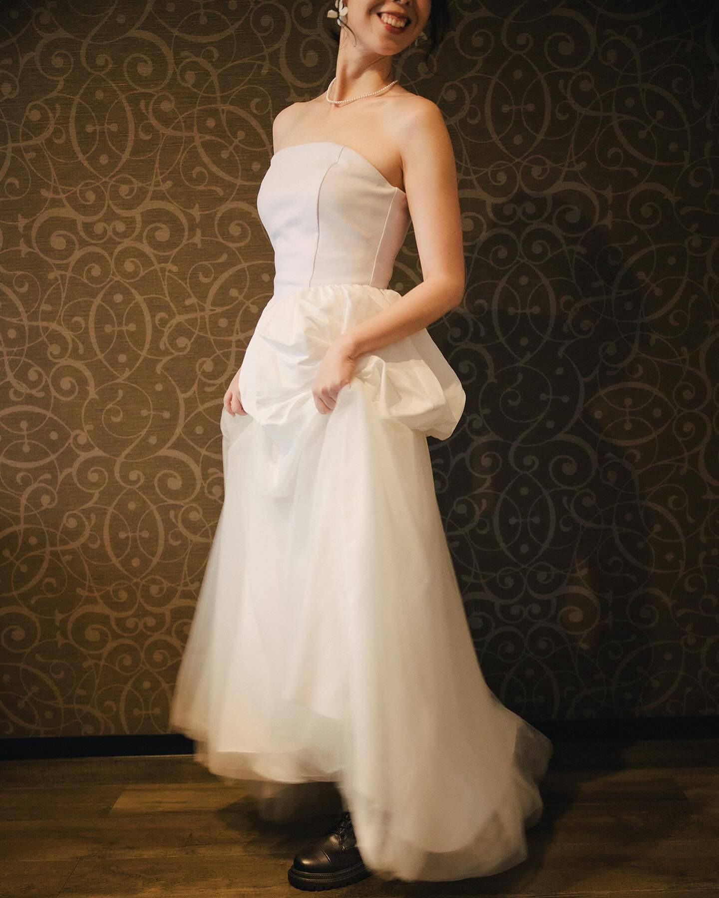 Styling of a strapless top with a balloon peplum and tulle skirt, worn with boots