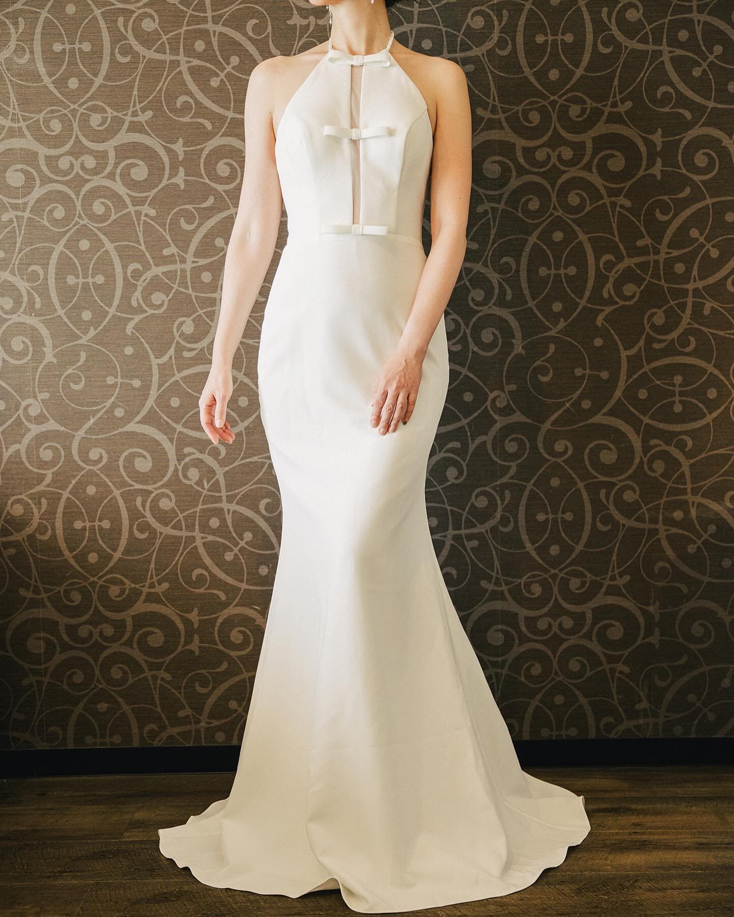 Front view of a halter-neck mermaid dress accented with small bows