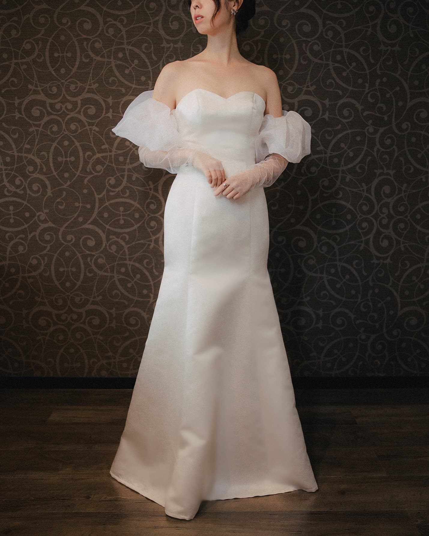 Full-length strapless sweetheart mermaid dress with sheer detachable puff sleeves, studio shot