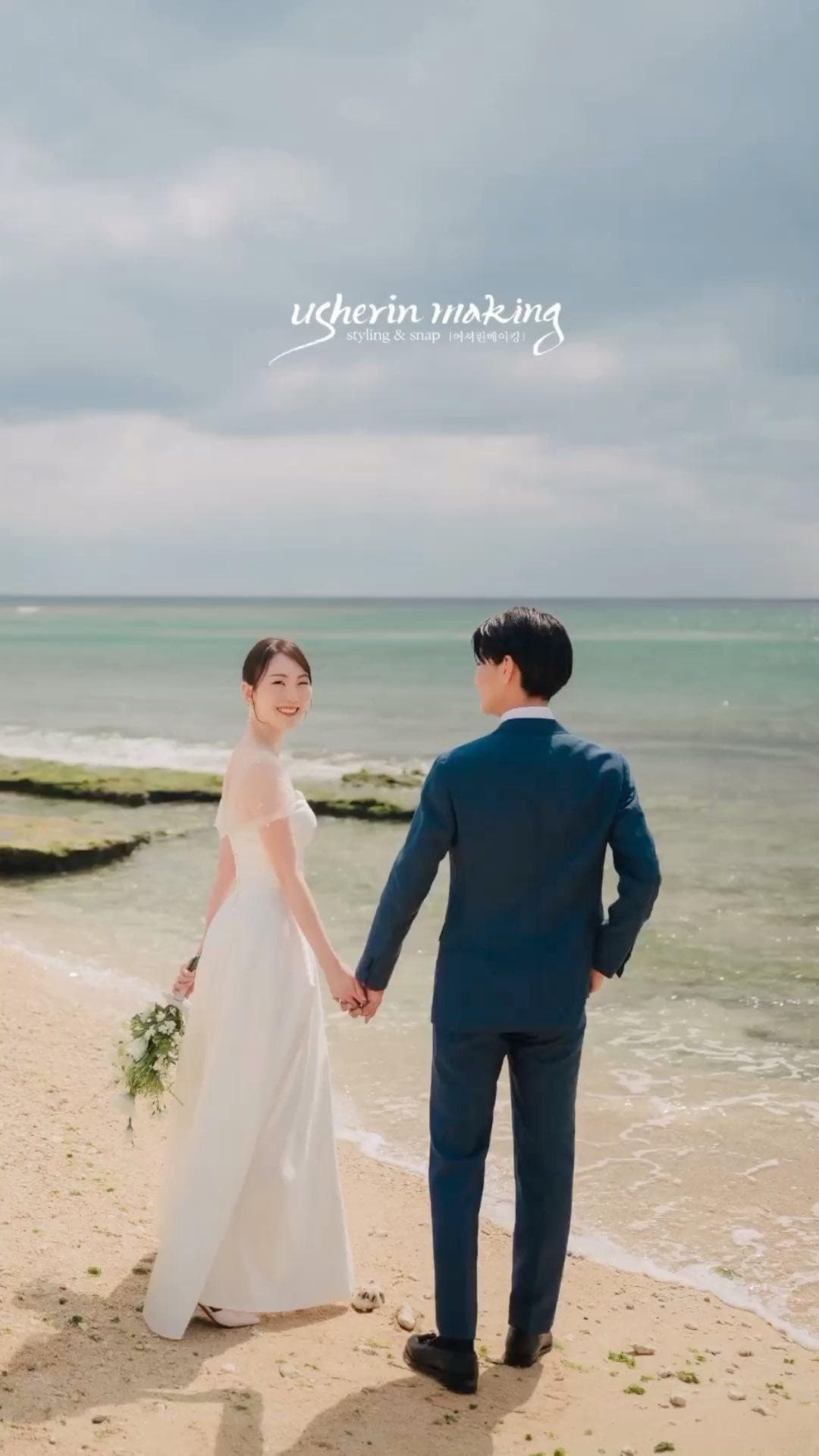Bride smiling back while holding hands with the groom on an Okinawa beach