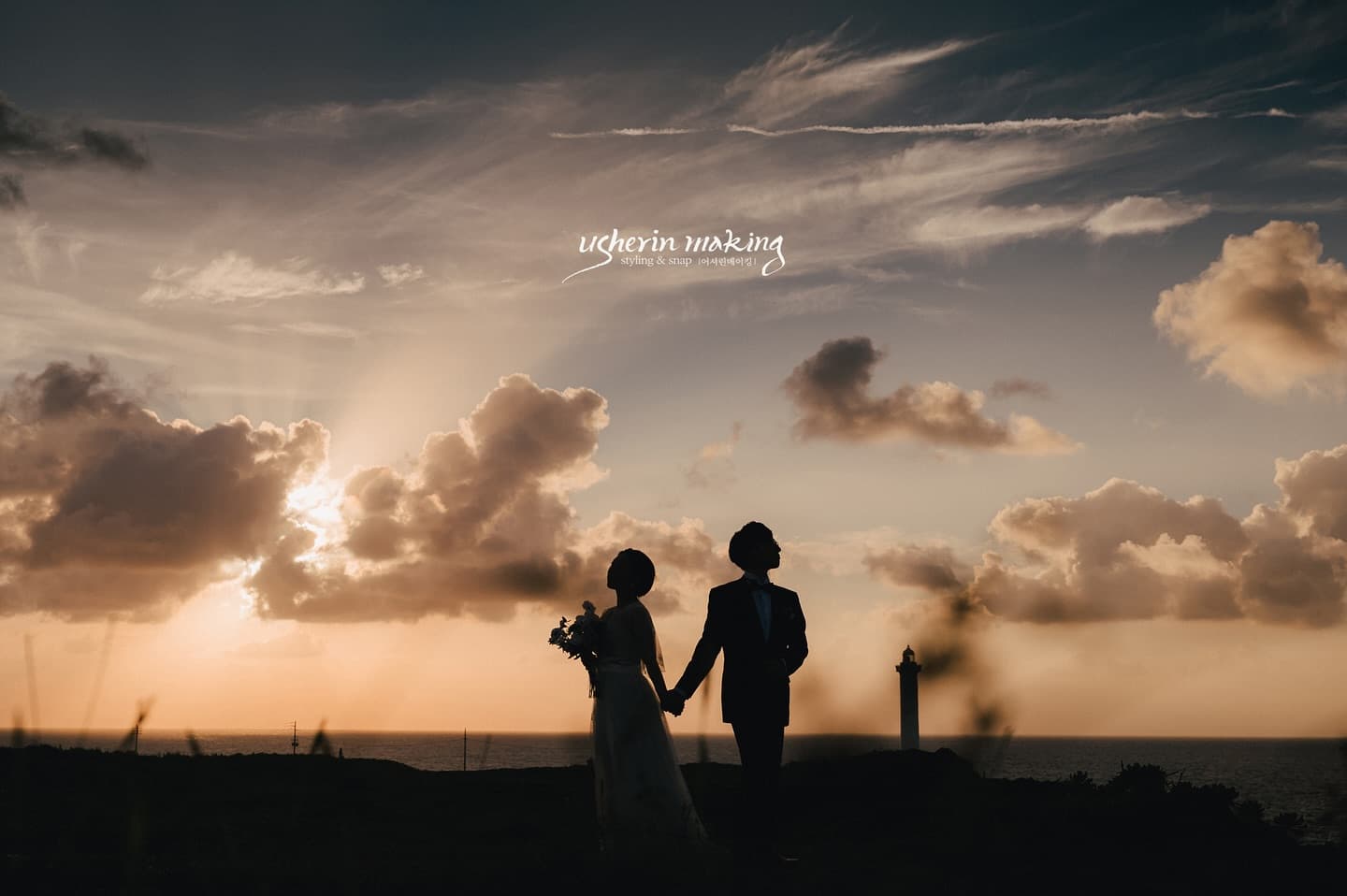 Silhouetted couple beneath a blazing sunset sky on an Okinawa cape