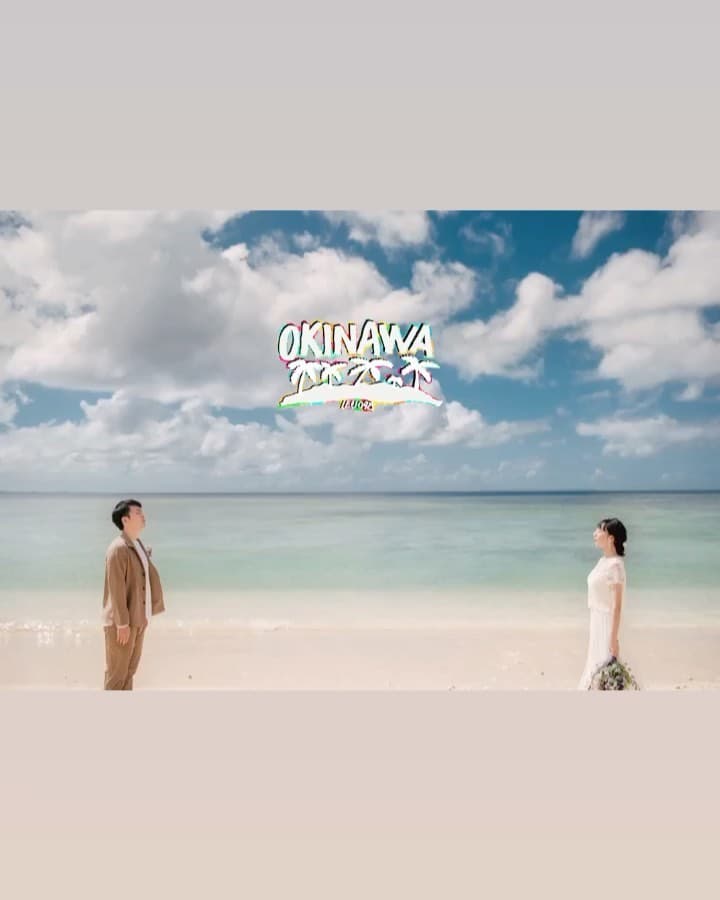 Bride and groom facing each other across a white-sand Okinawa beach