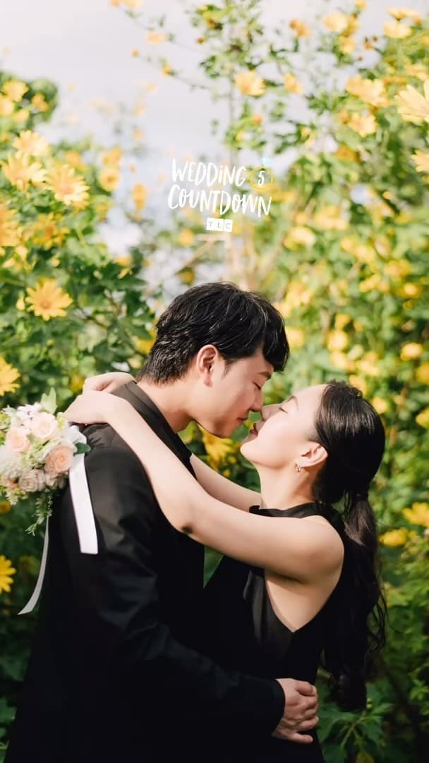 黄色い花が咲き誇る花畑でキスを交わそうとする二人、沖縄のウェディングフォト