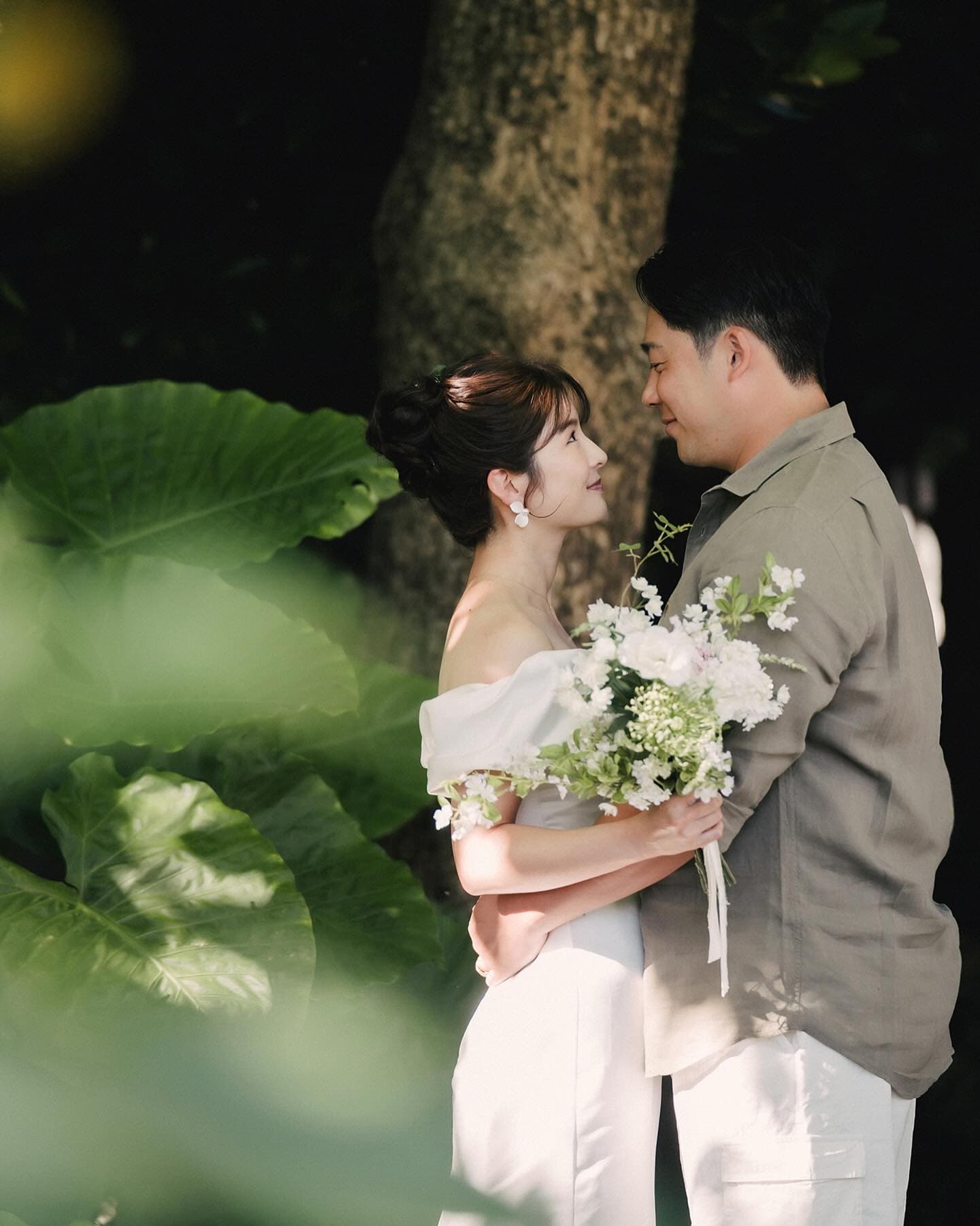 Couple gazing at each other under a shady tree in Okinawa