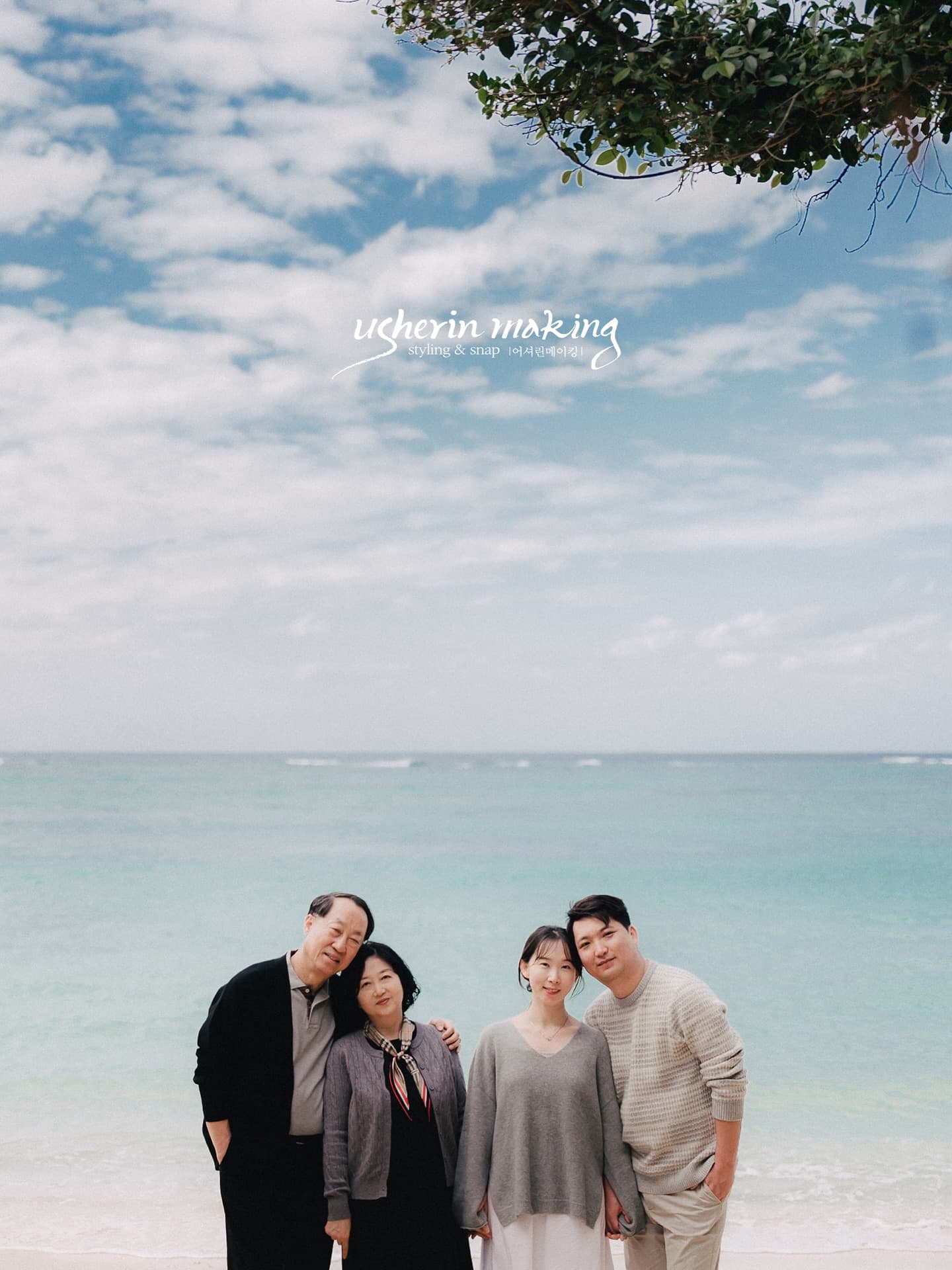 Two-generation family standing close together on an Okinawa beach under a blue sky