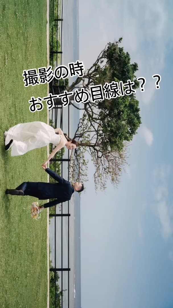Bride and groom joining hands on a grassy field in Okinawa