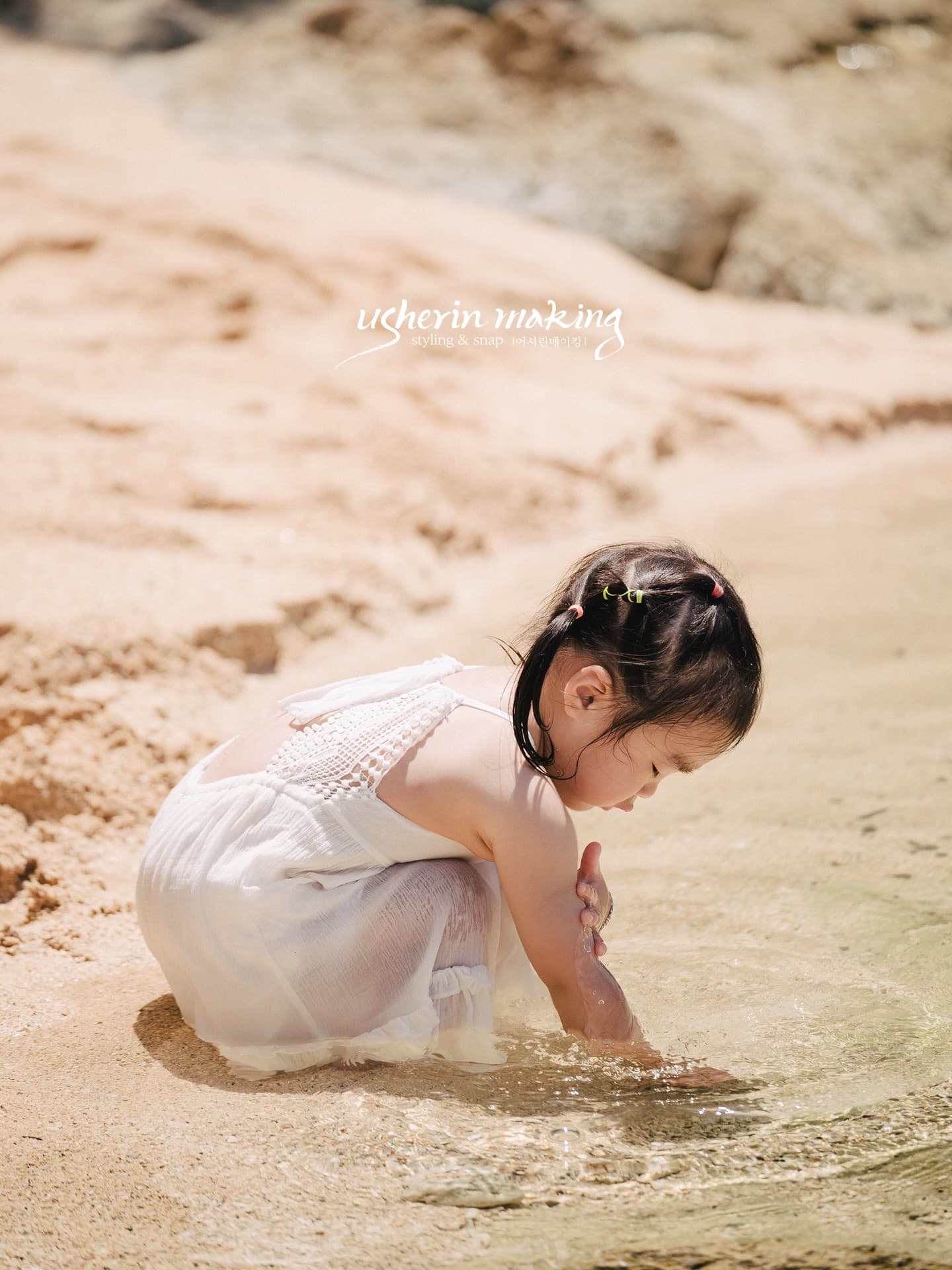 Little girl in white playing in the shallows on an Okinawa beach