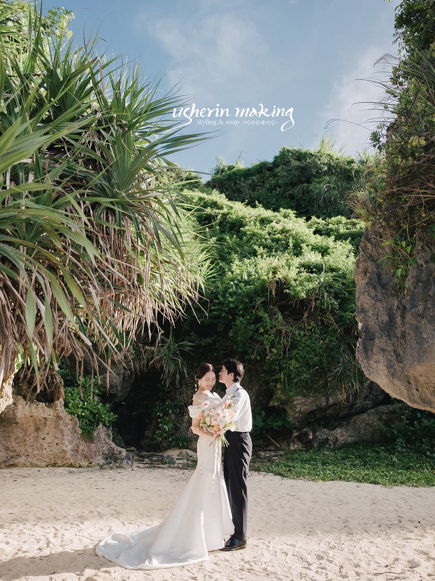 Bride and groom embracing among pandanus and sea cliffs in Okinawa