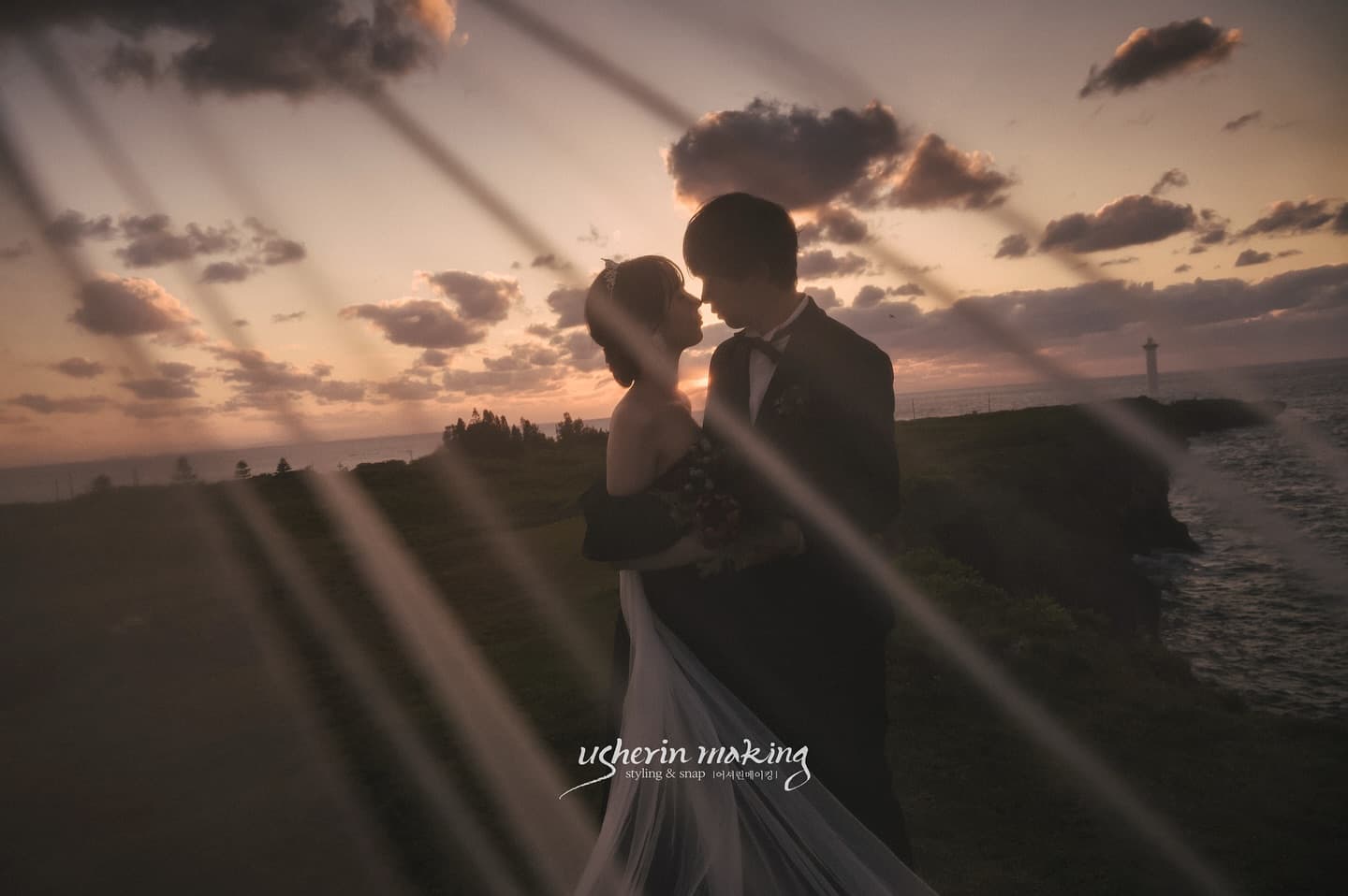 Silhouetted couple embracing on an Okinawa cape as sunset rays streak the sky