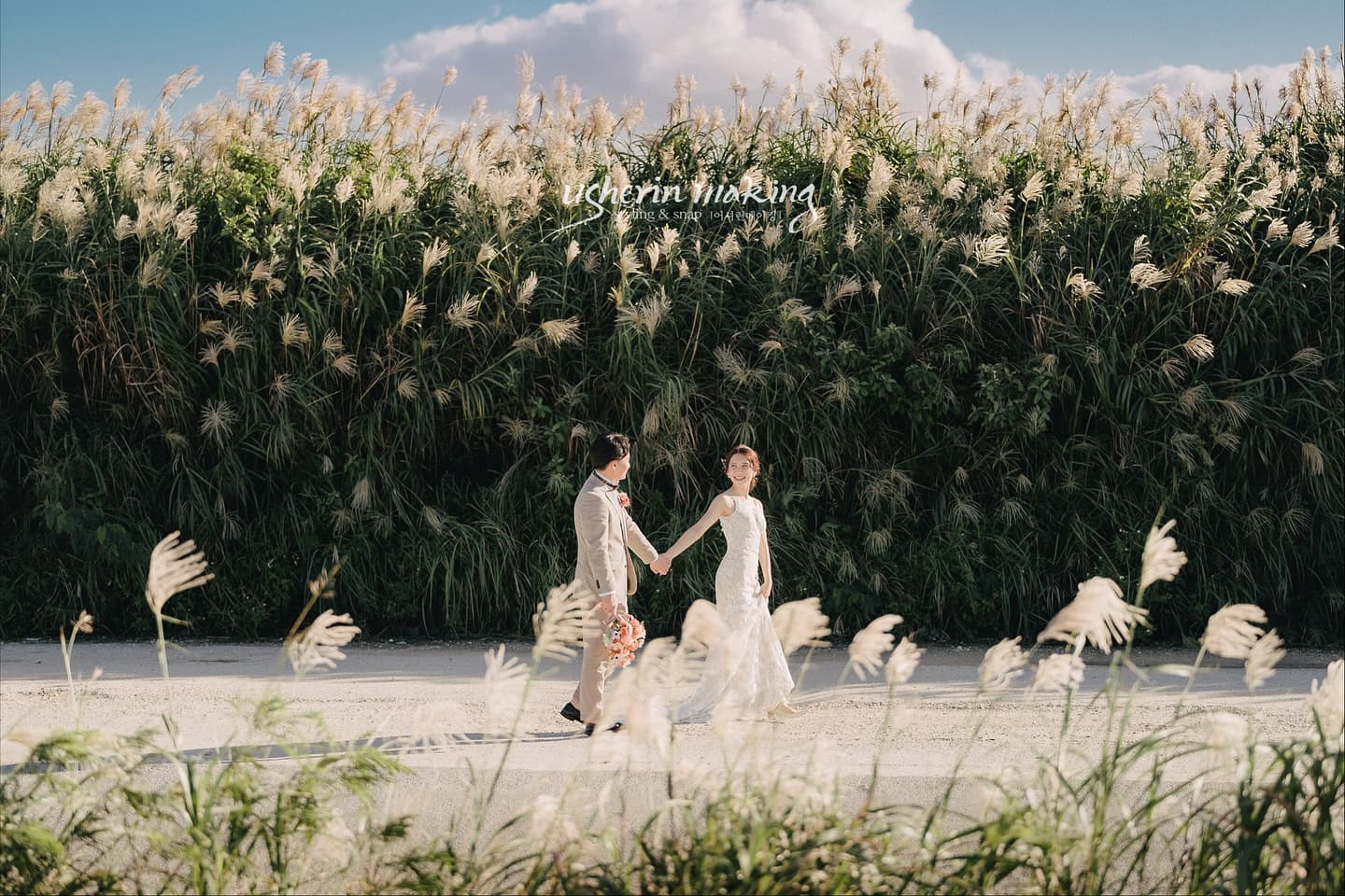 Couple walking hand in hand past autumn pampas grass in Okinawa