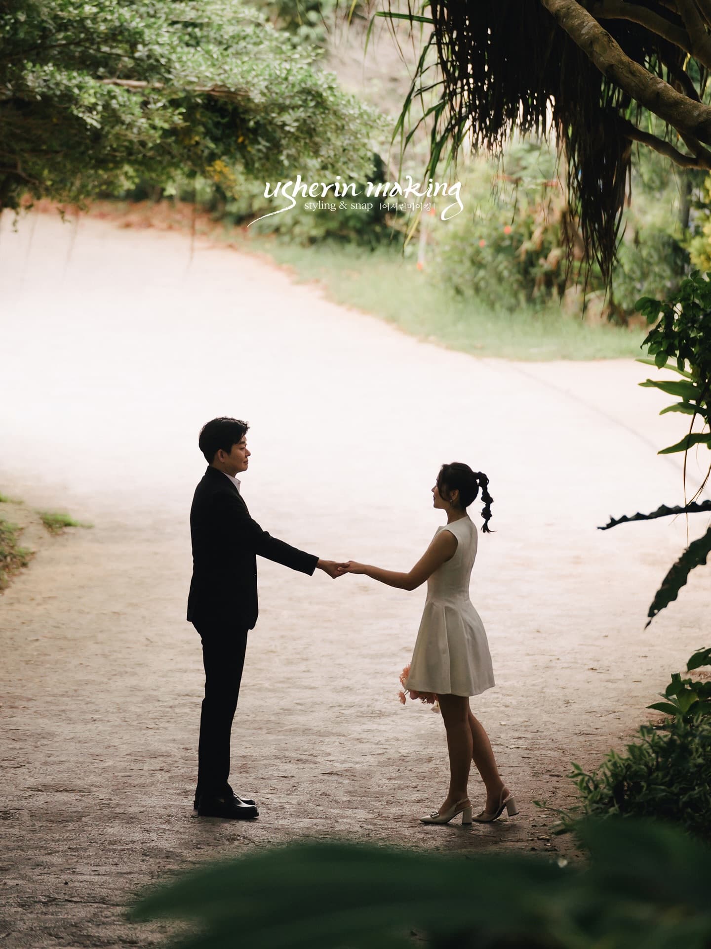 Couple holding hands face to face on a forest path in Okinawa