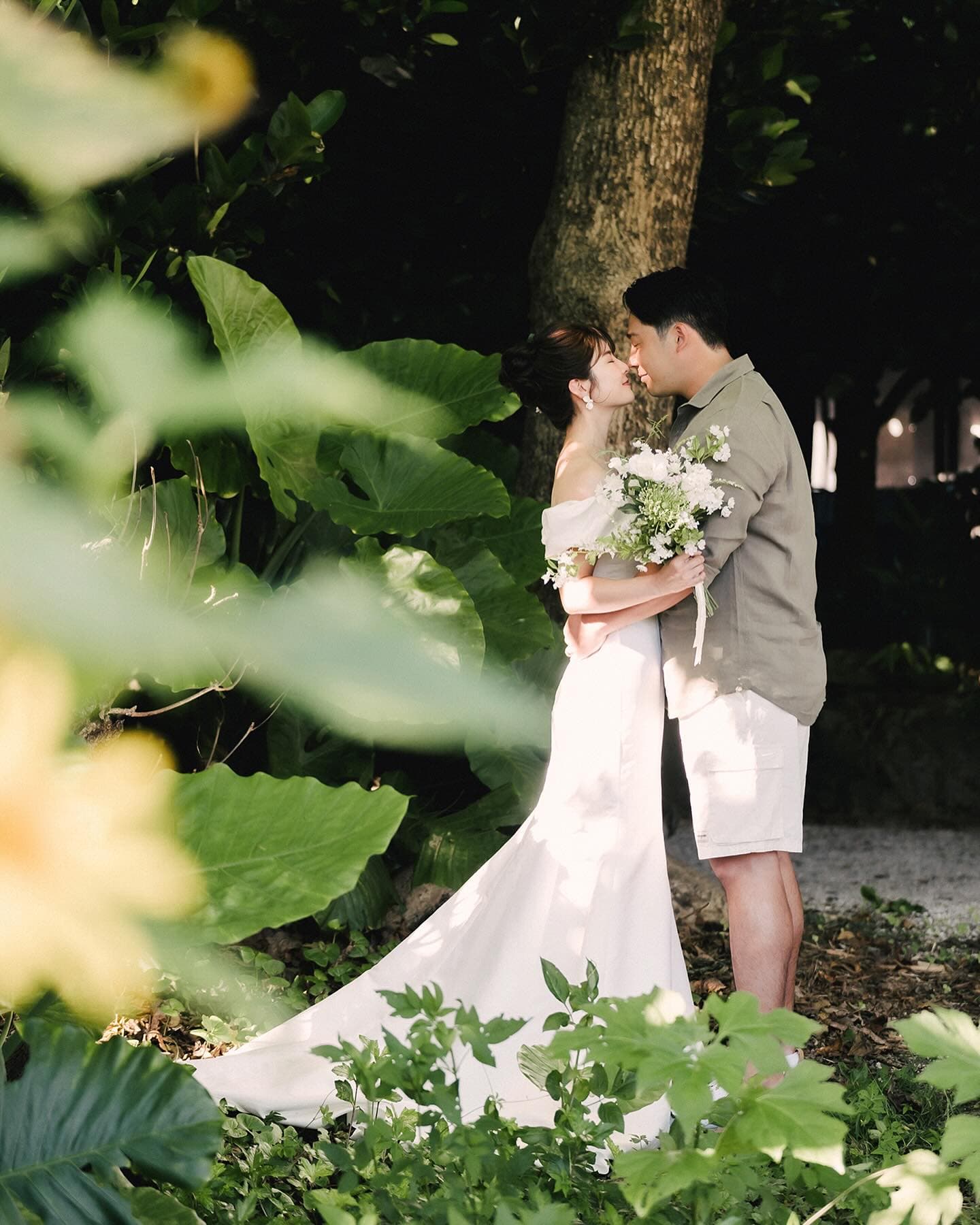 Couple touching foreheads in lush tropical shade in Okinawa