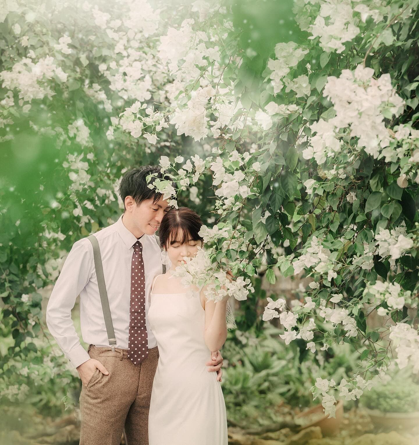 Couple nestled among white blossoms on a Miyakojima photo shoot